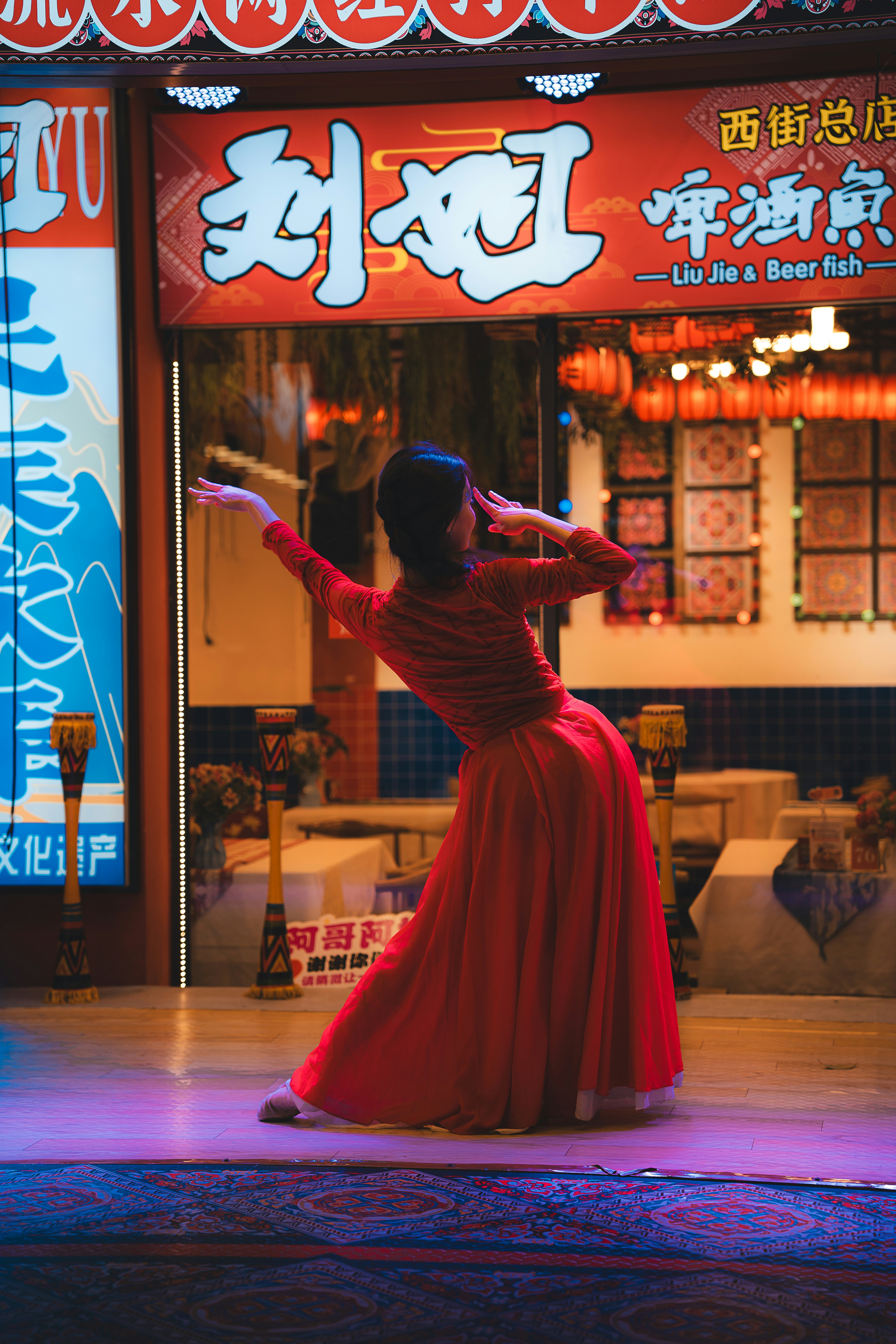 Mulher de vestido vermelho dançando no palco no palco