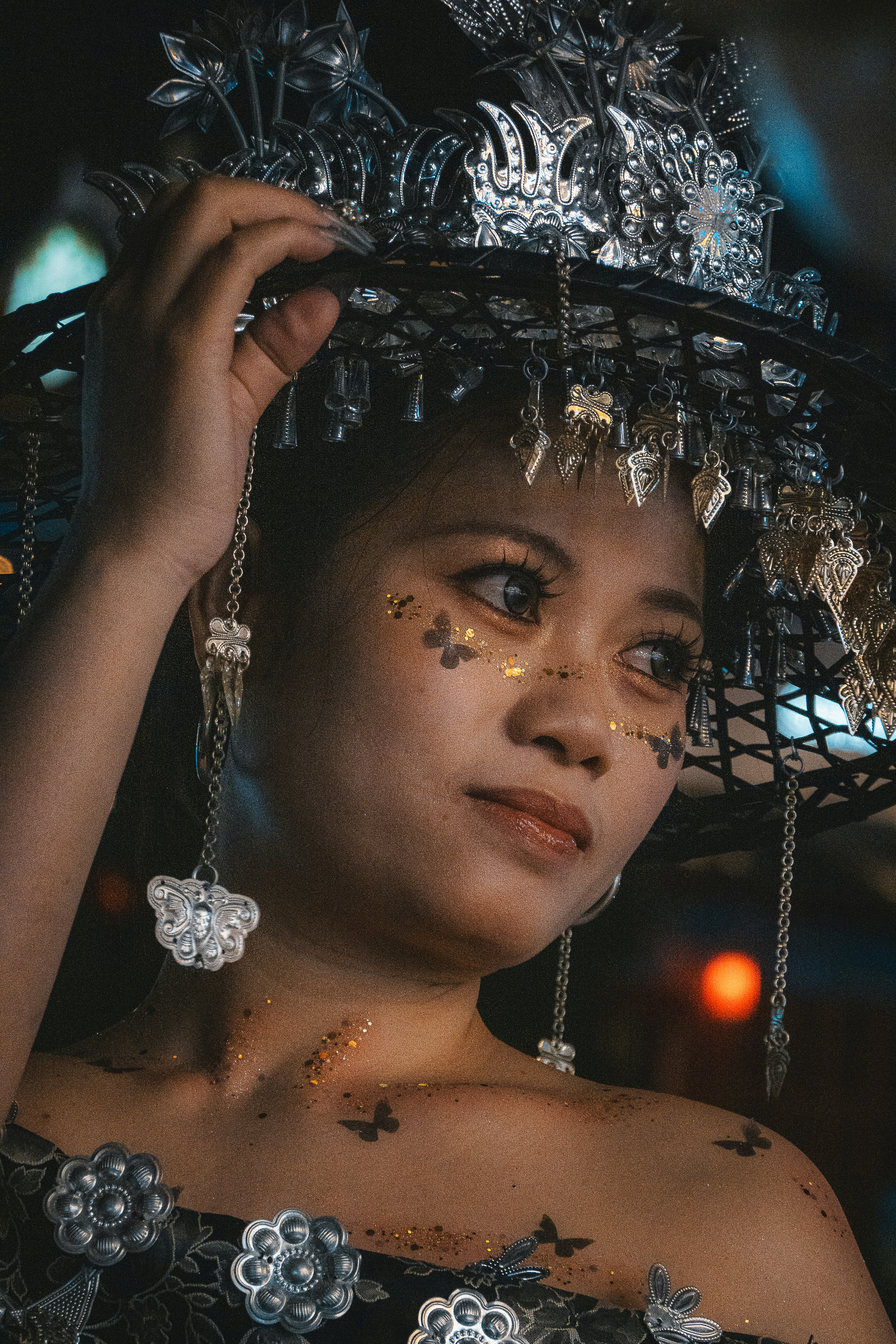 Mulher com cocar ornamentado e maquiagem no rosto em forma de borboleta