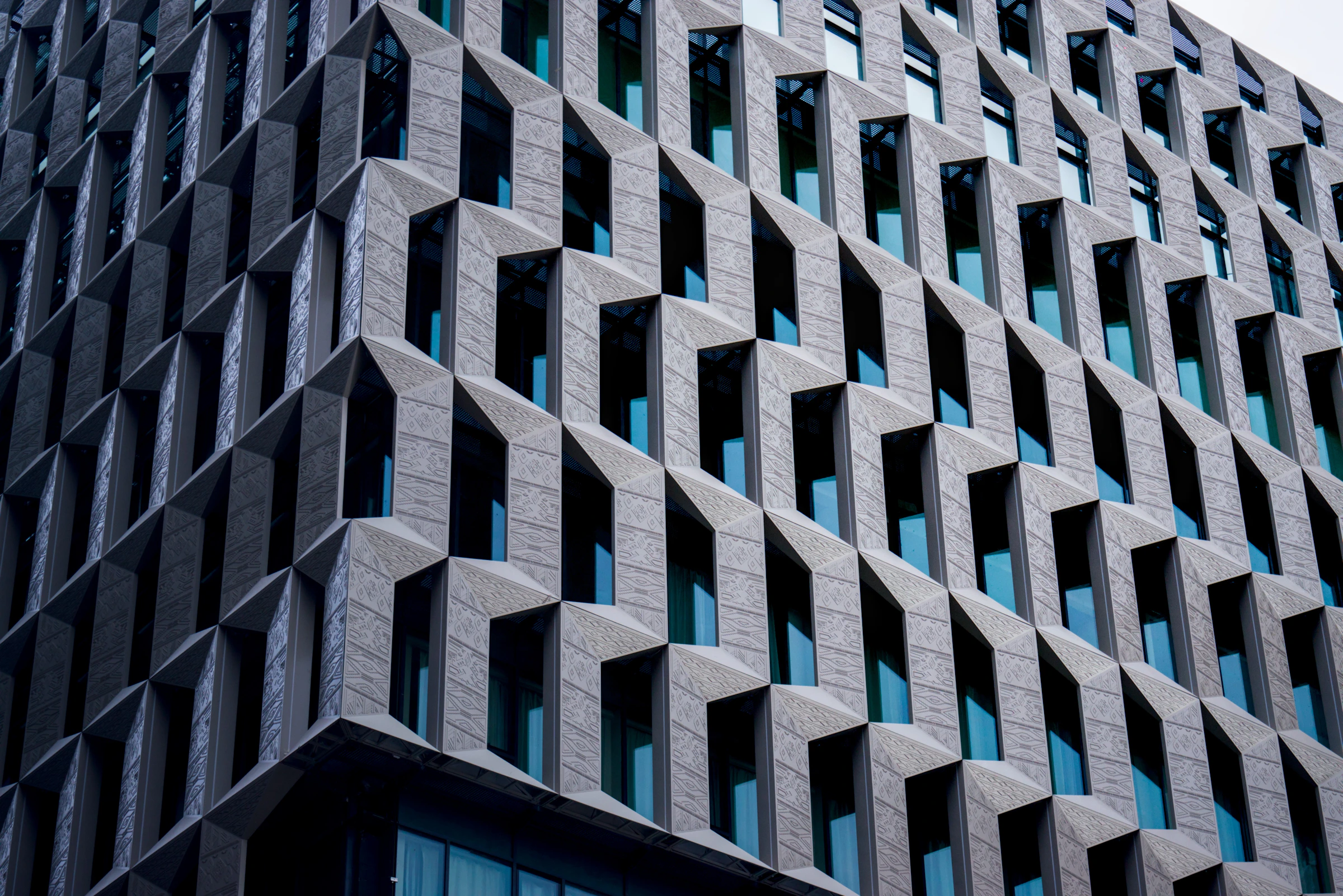 Modern building facade with geometric patterns and blue windows