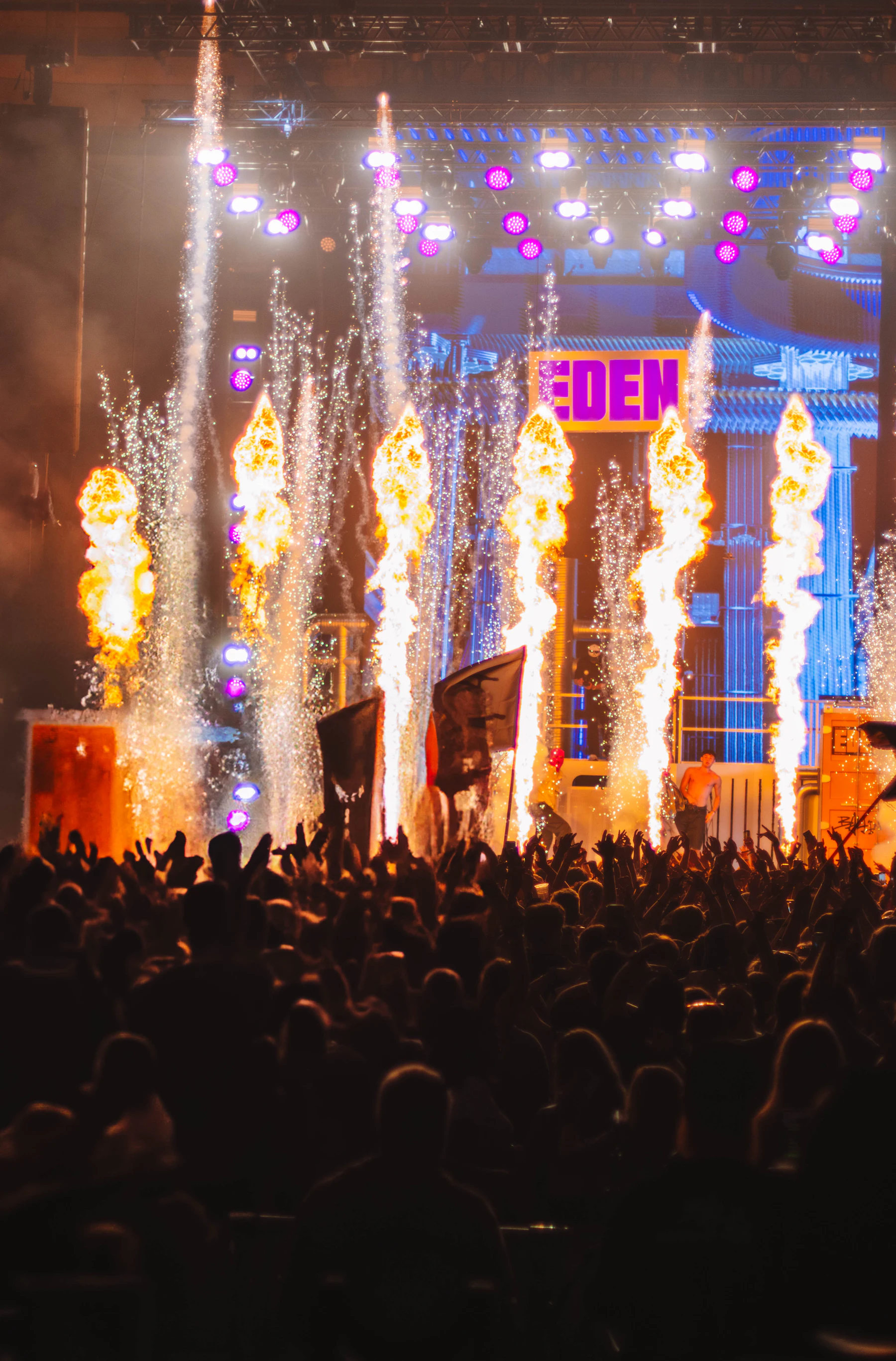 Stage pyro and flame jets firing over a concert crowd