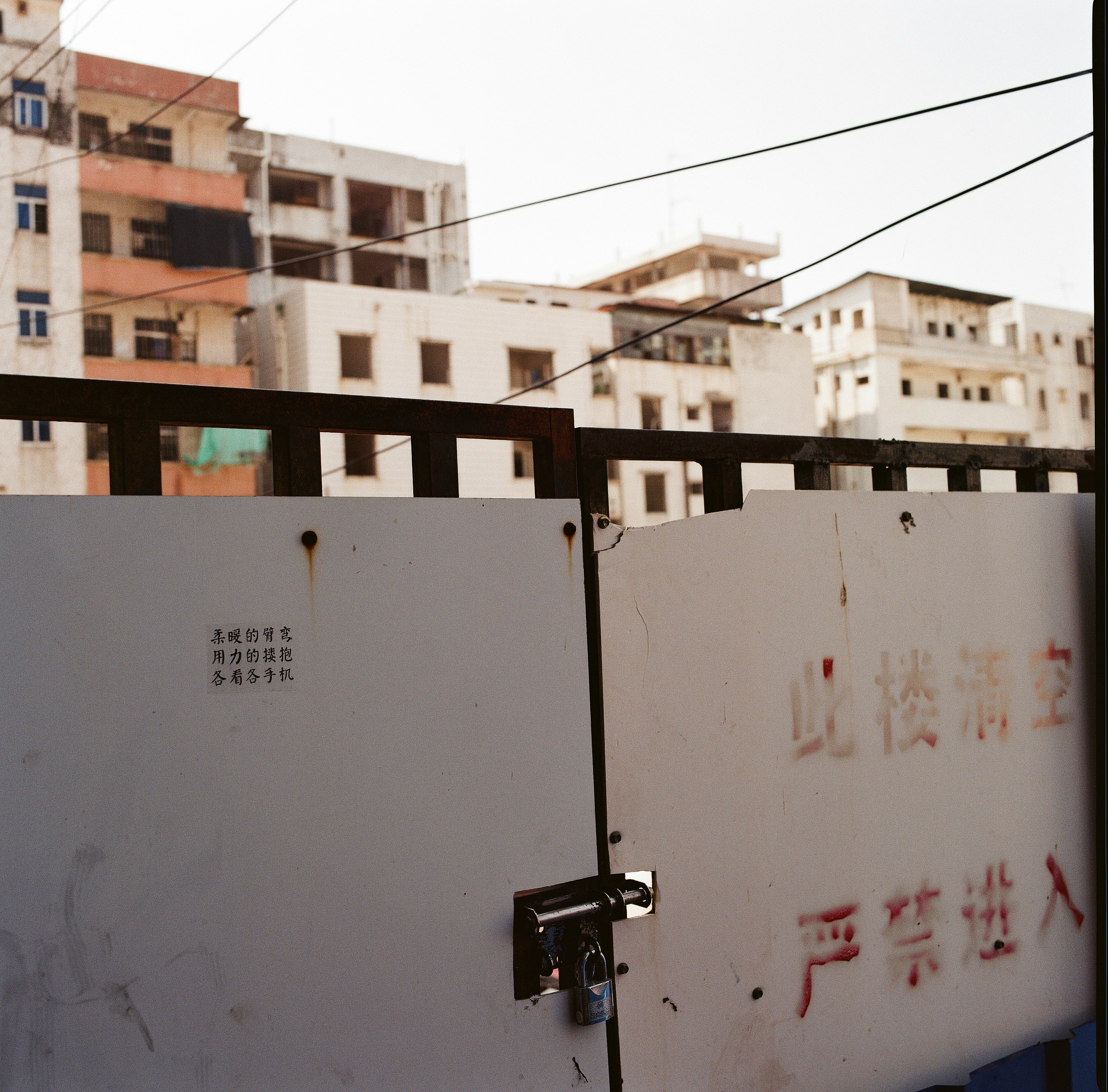 White gate with chinese text and padlock