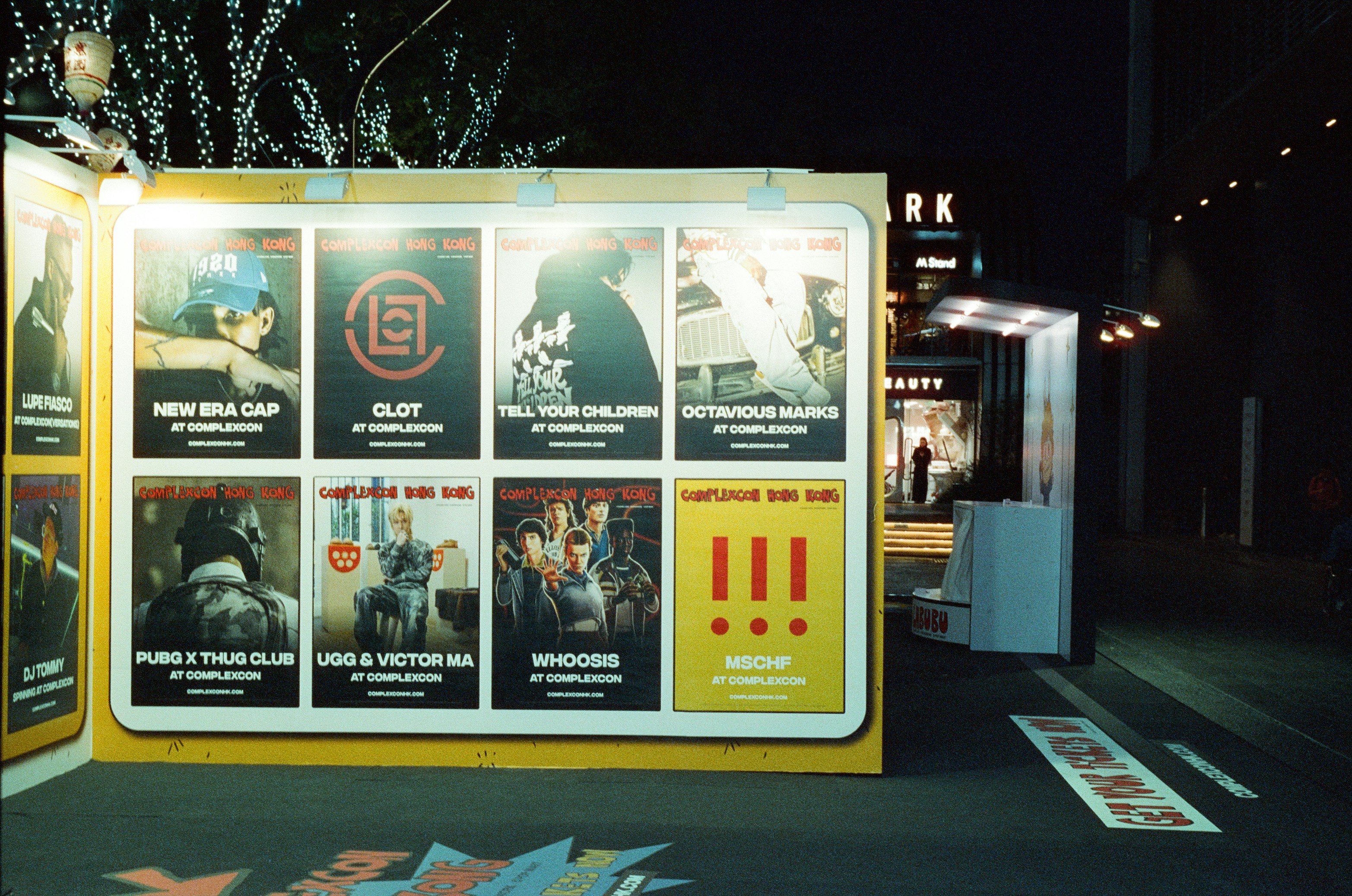 Posters displayed on a yellow wall at night