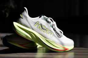 Pair of white hoka running shoes with lime green soles
