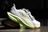 Pair of white hoka running shoes with lime green soles