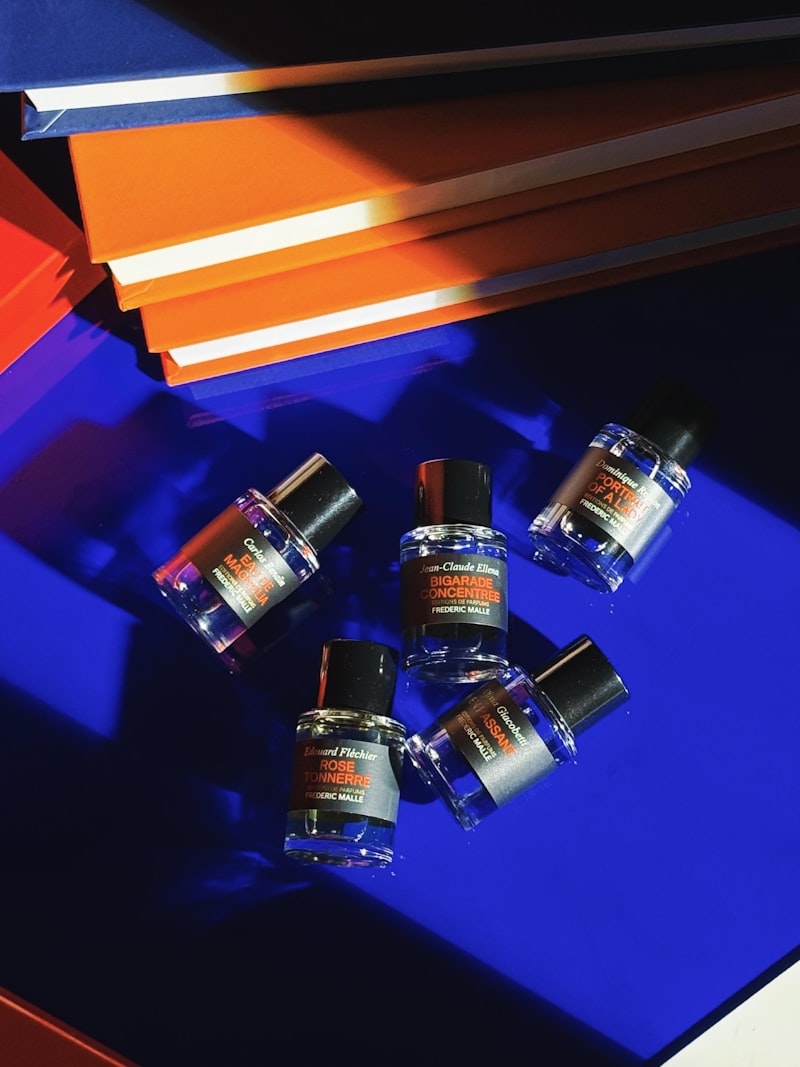 Fuenf kleine Parfumflakons auf blauem Untergrund
