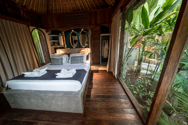 Cozy bedroom with large window overlooking lush greenery