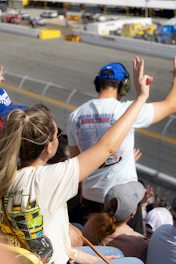Spectators watch a race from stadium seating.