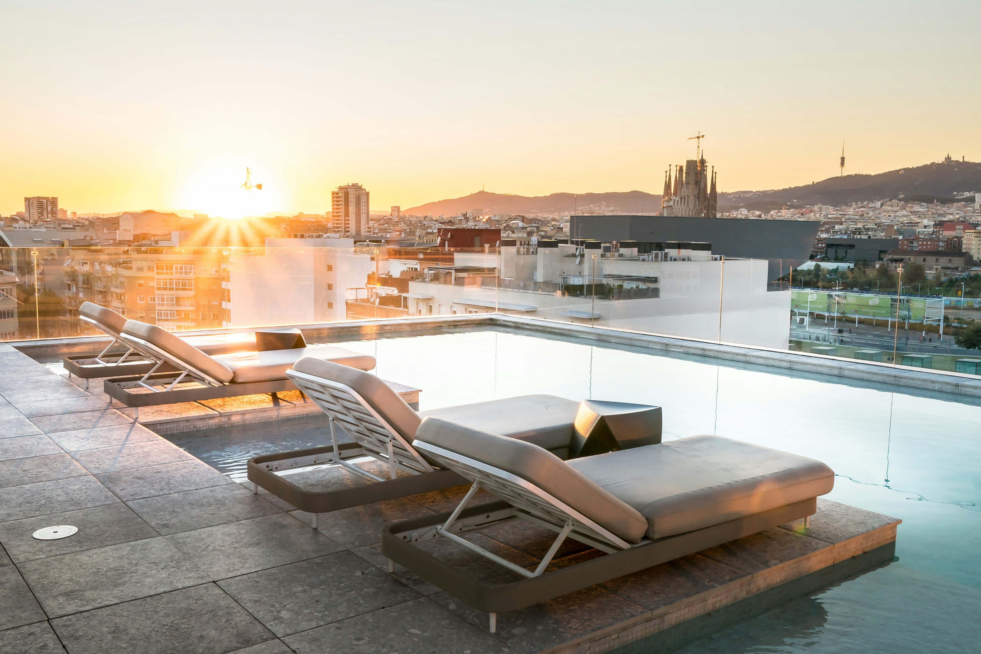 Rooftop pool with city skyline at sunset