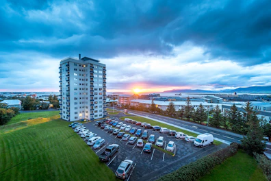 High-rise building with parking lot at sunset