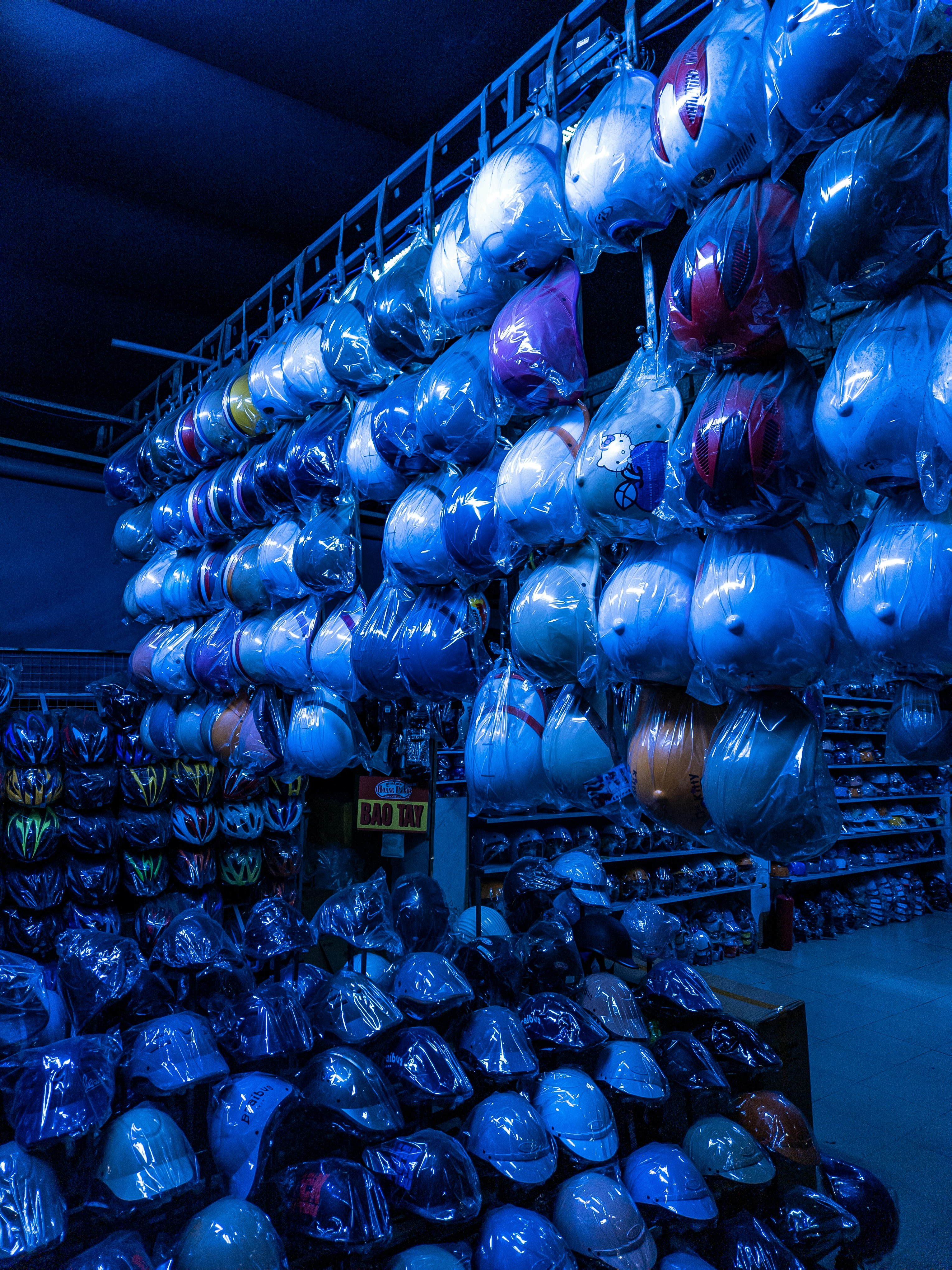 Rows of motorcycle helmets displayed in a store.