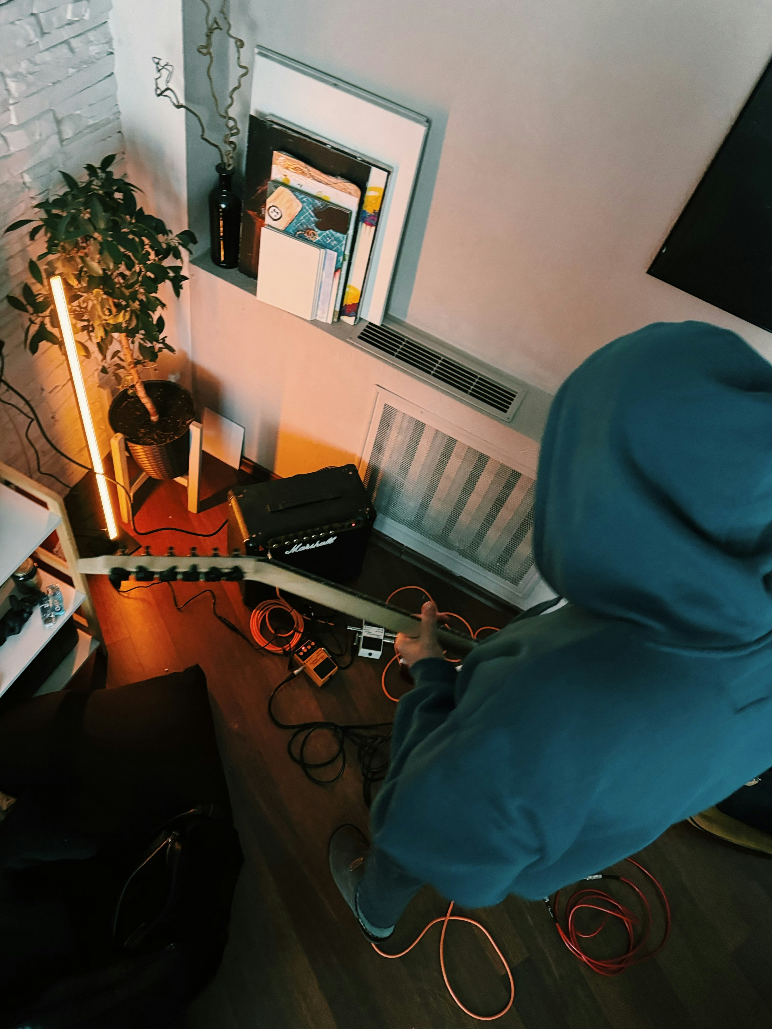 Person playing electric guitar in a room