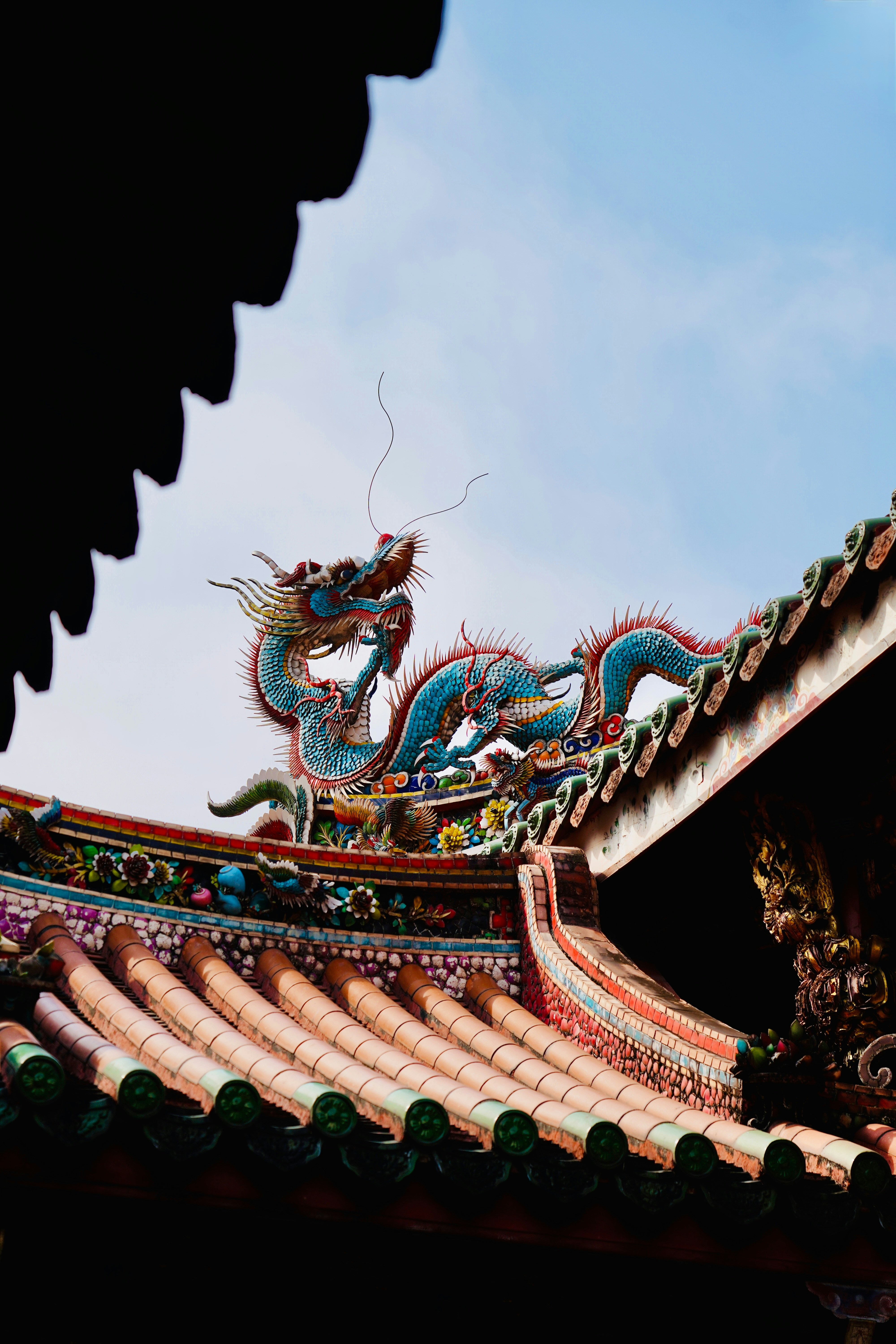 Un dragón azul adorna el colorido techo de un templo.