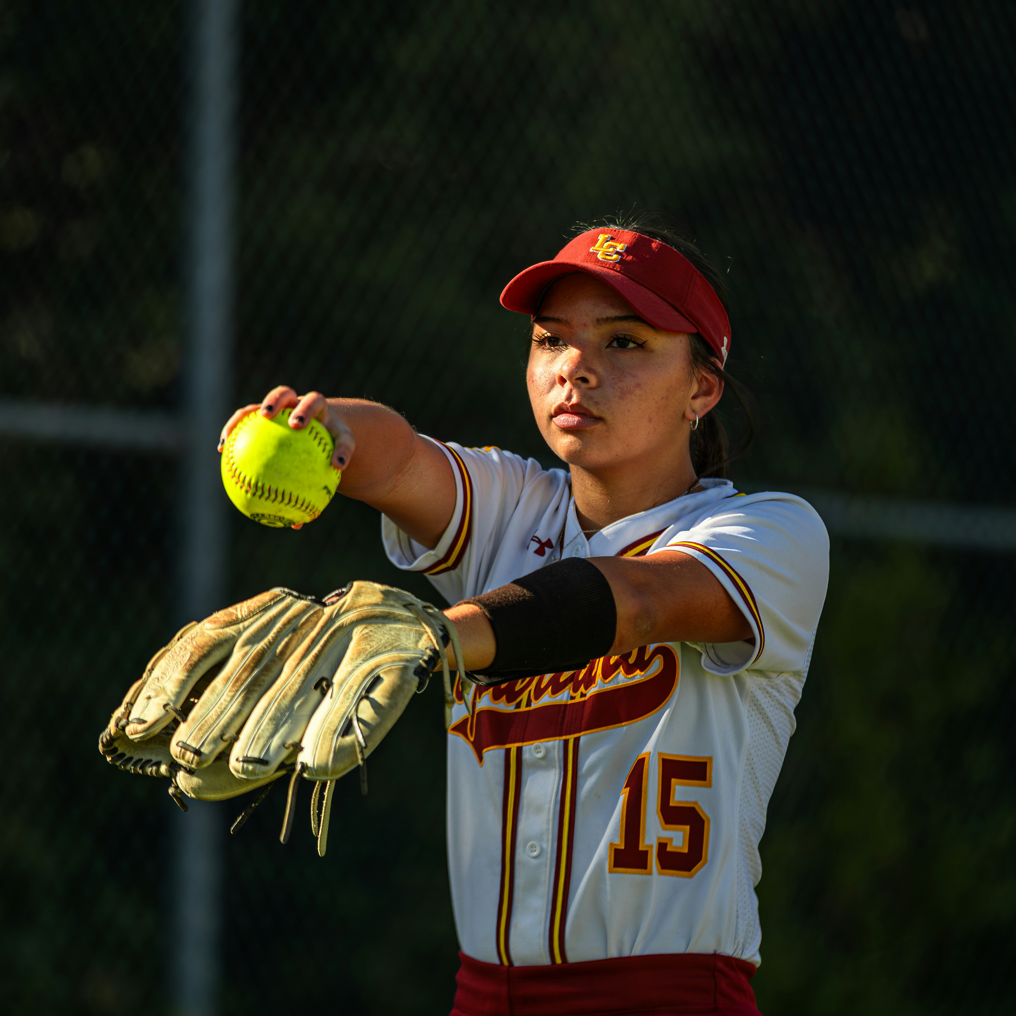 A female softball pitcher preparing to throw the ball.