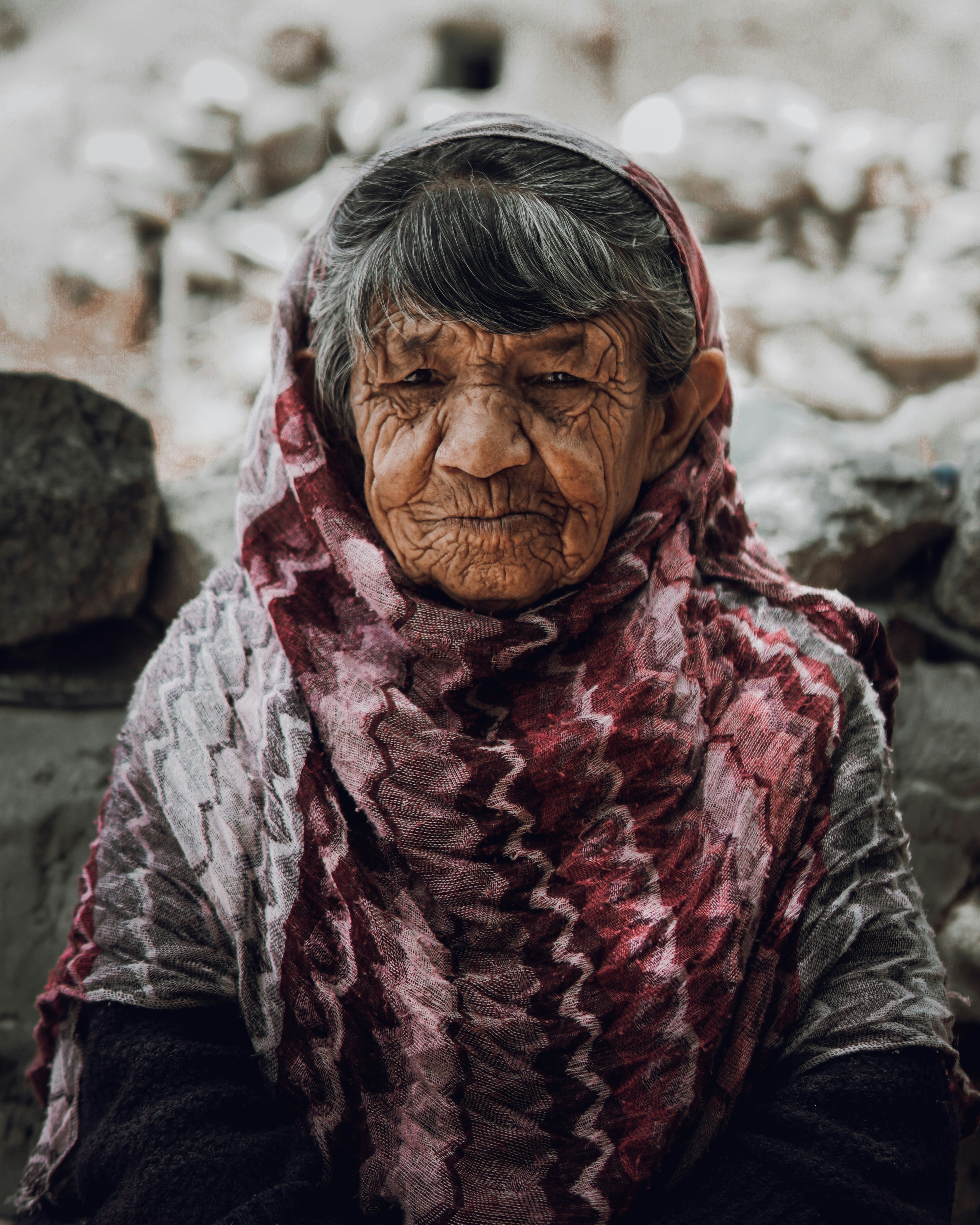 Una anciana con piel curtida y una bufanda con estampados.