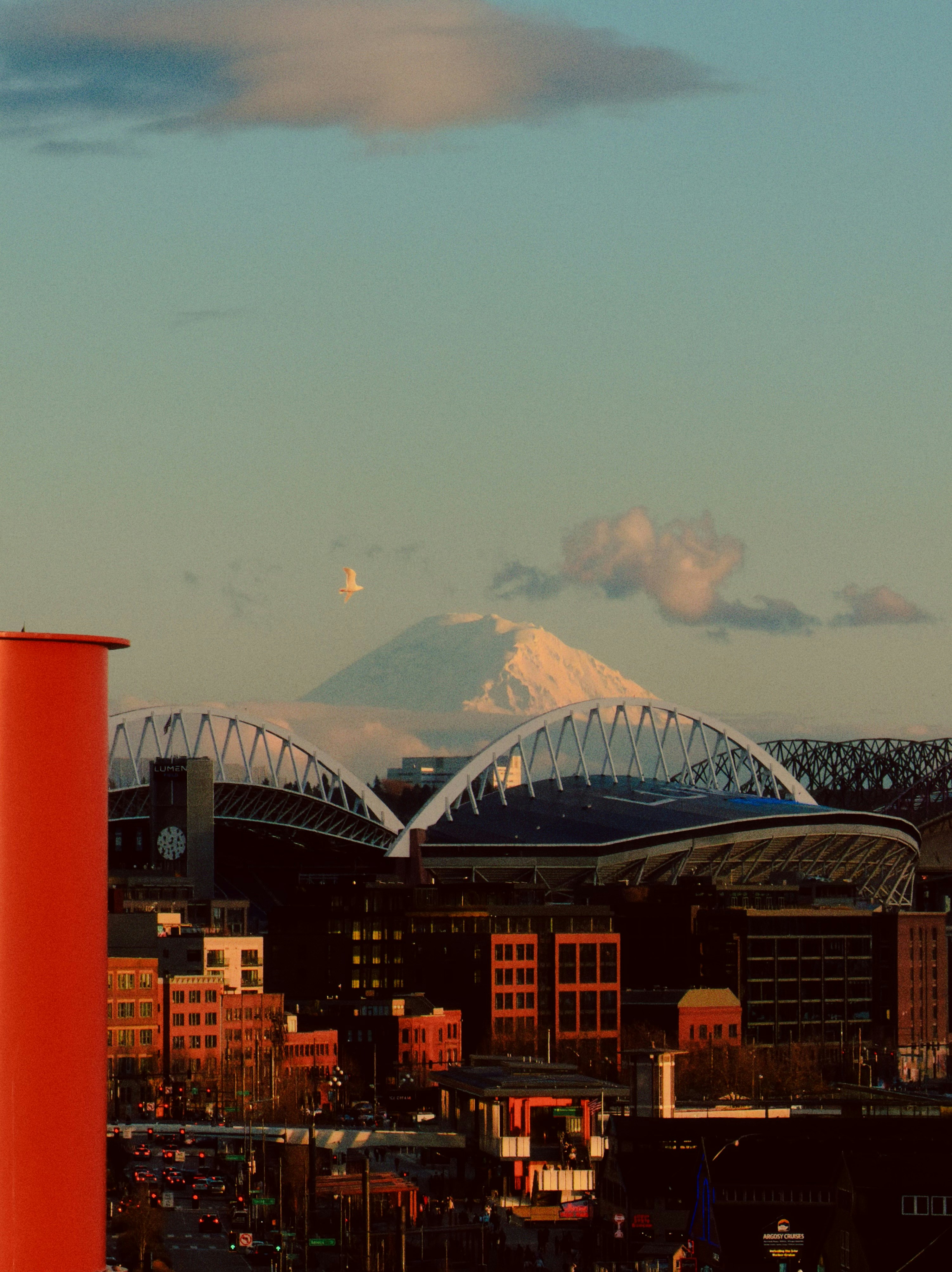 City skyline with mountain and stadium at sunset