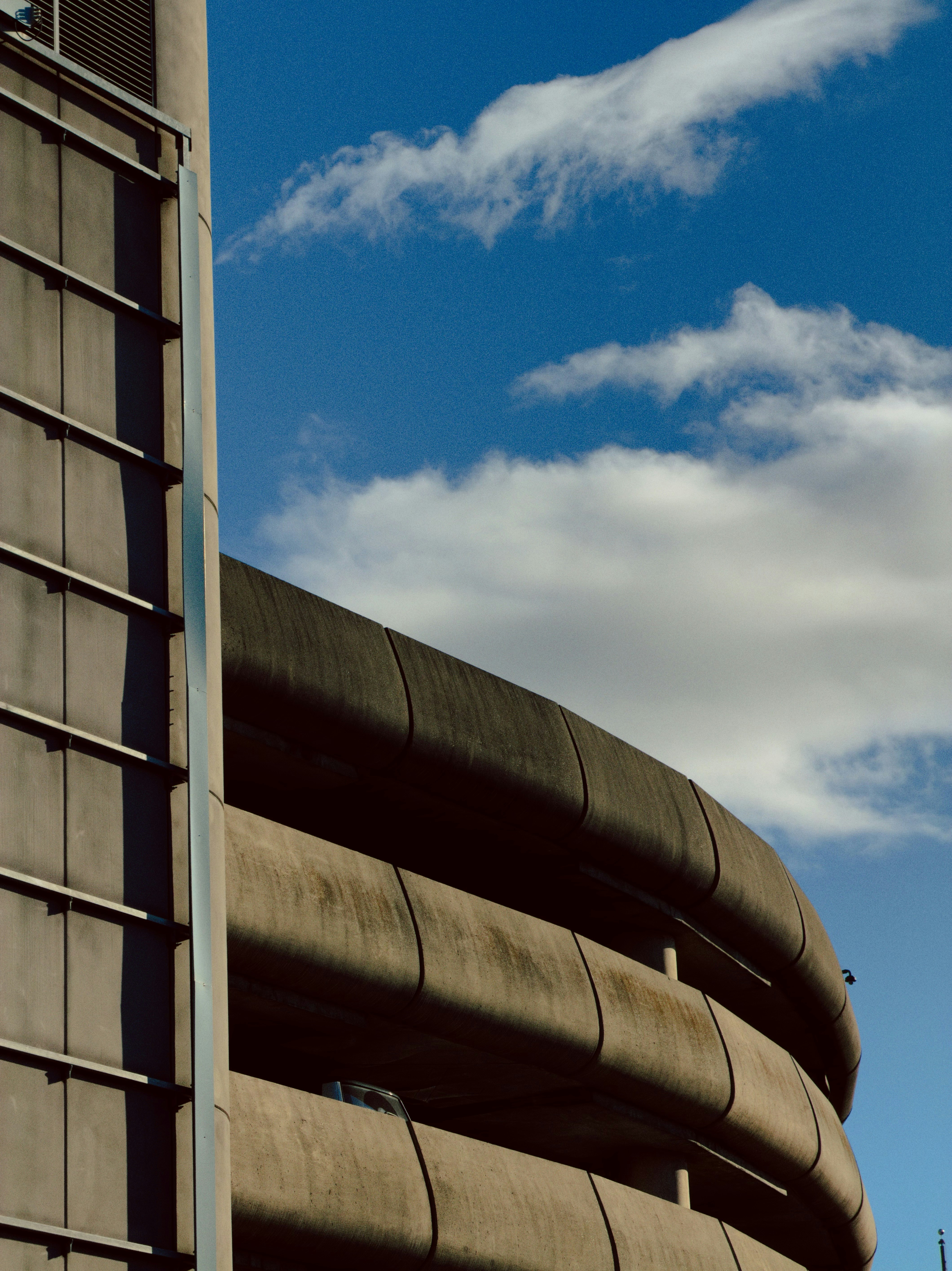 콘크리트 건물이 파란 하늘을 배경으로 곡선을 이룬다.