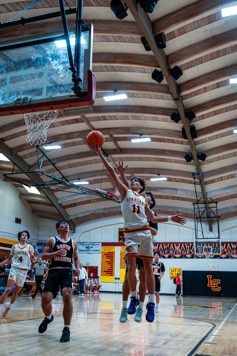 Basketball players jumping for a shot near the hoop
