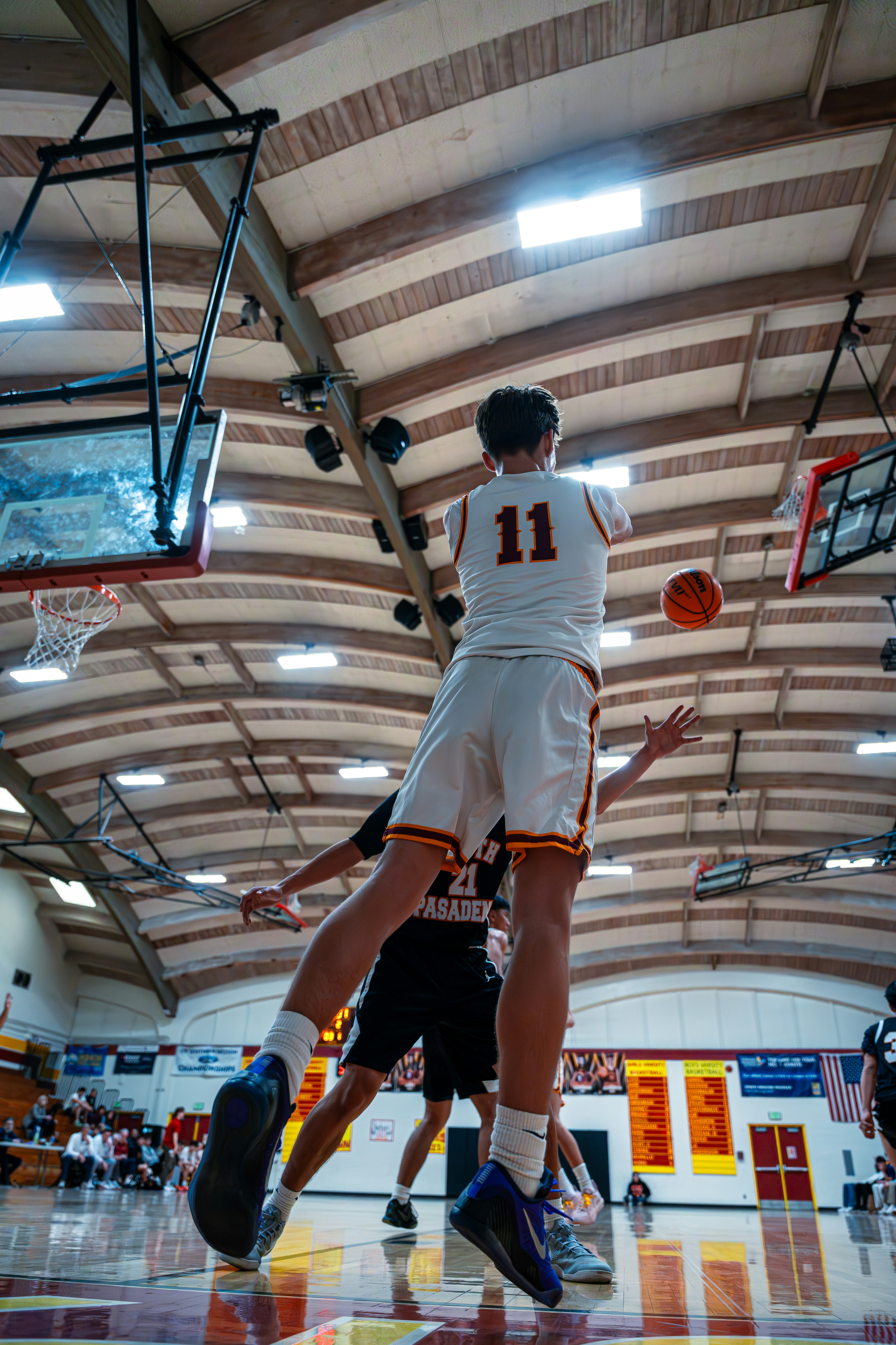 Teenage basketball player jumping for a shot.