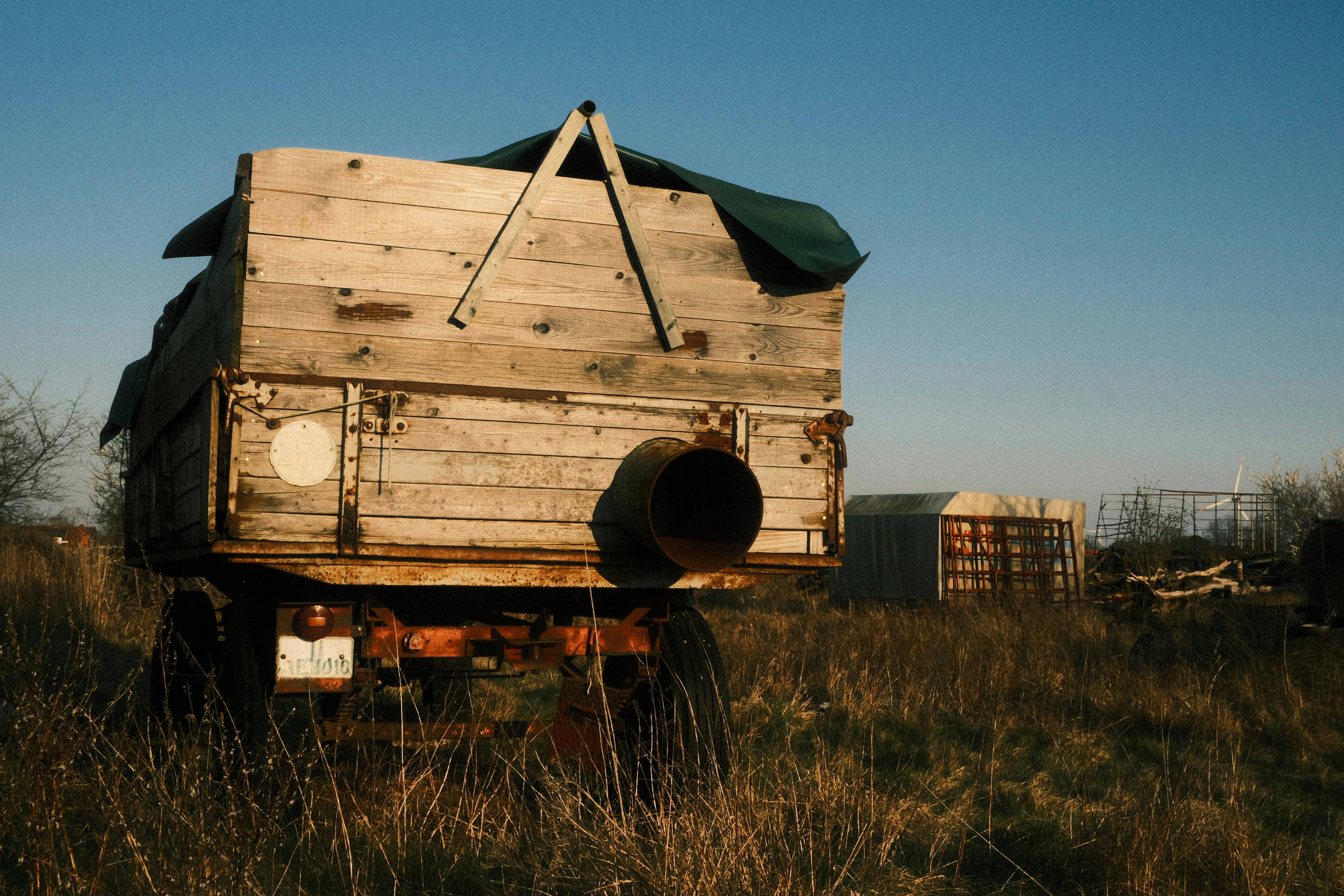 Old wooden trailer in a dry grassy field