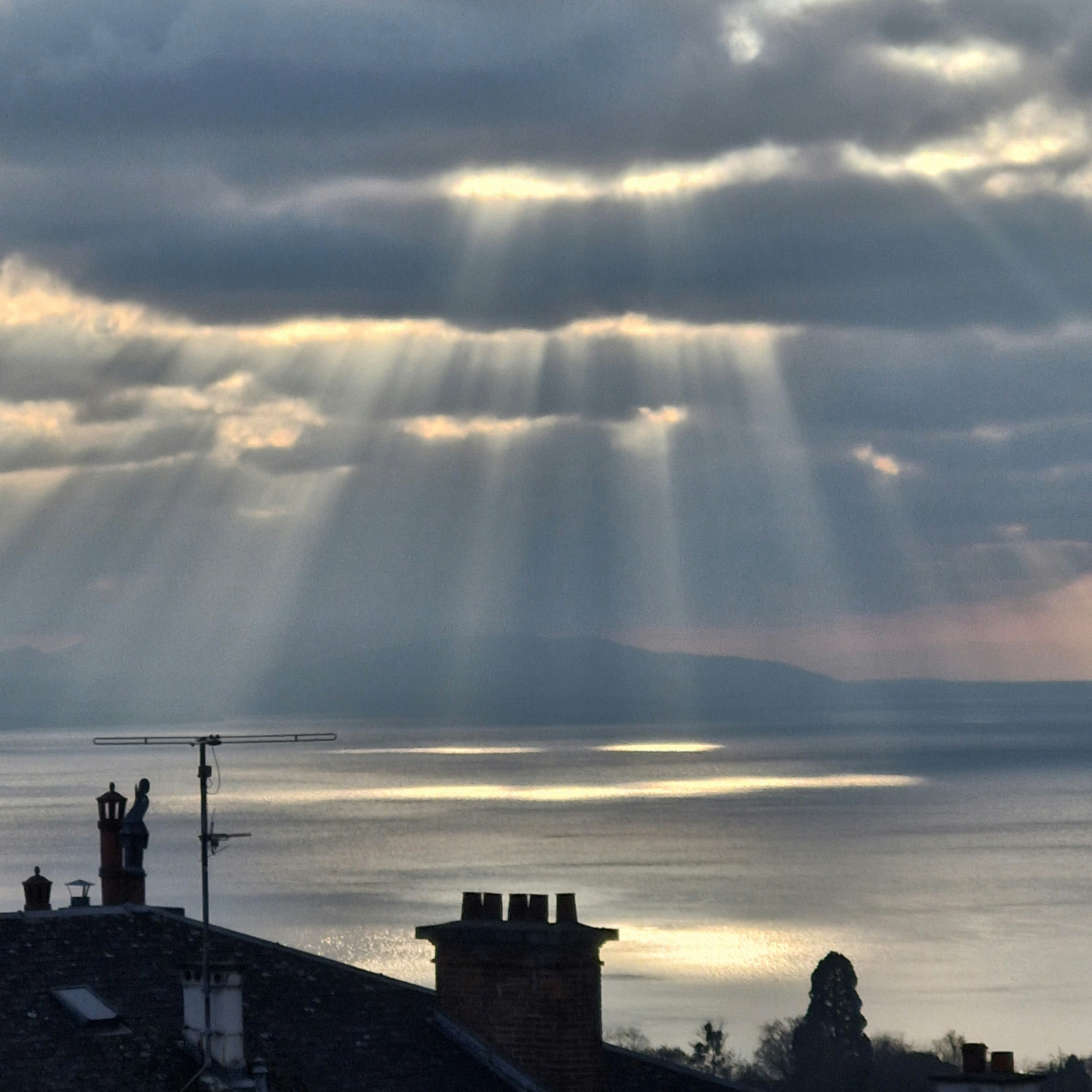 Sunbeams break through dramatic clouds over the ocean