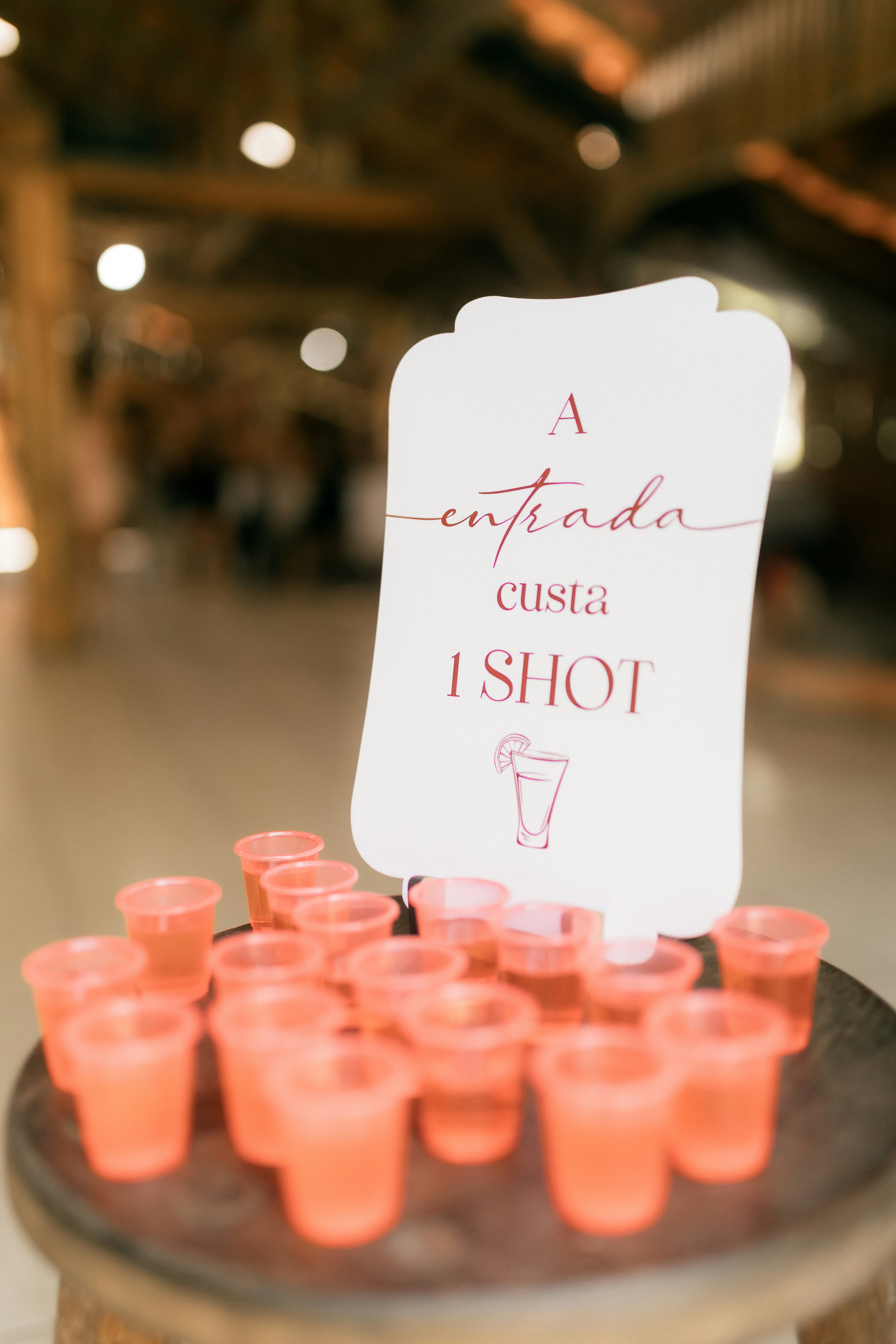 Pink shot glasses arranged with a sign