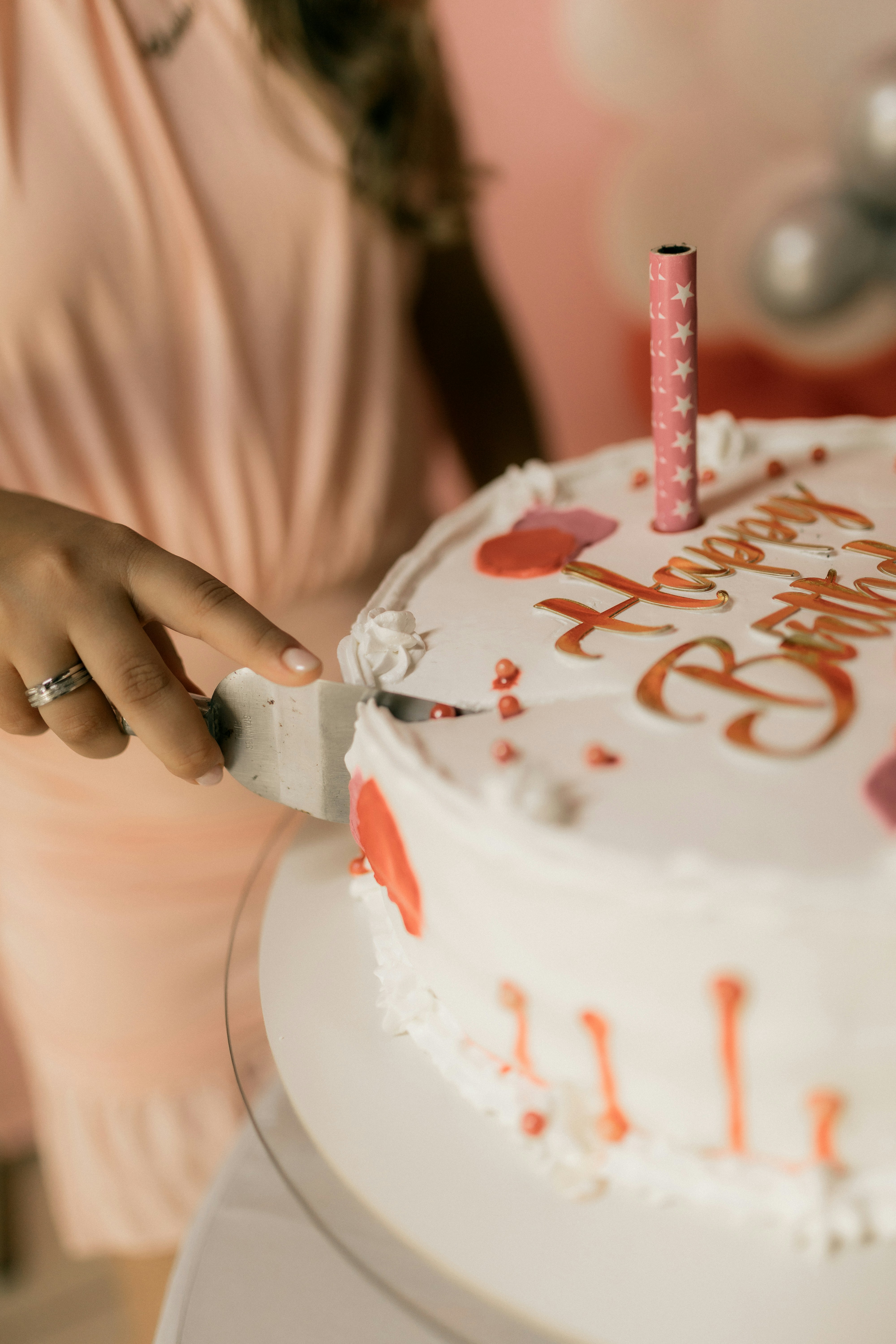 Pessoa cortando um bolo de feliz aniversário