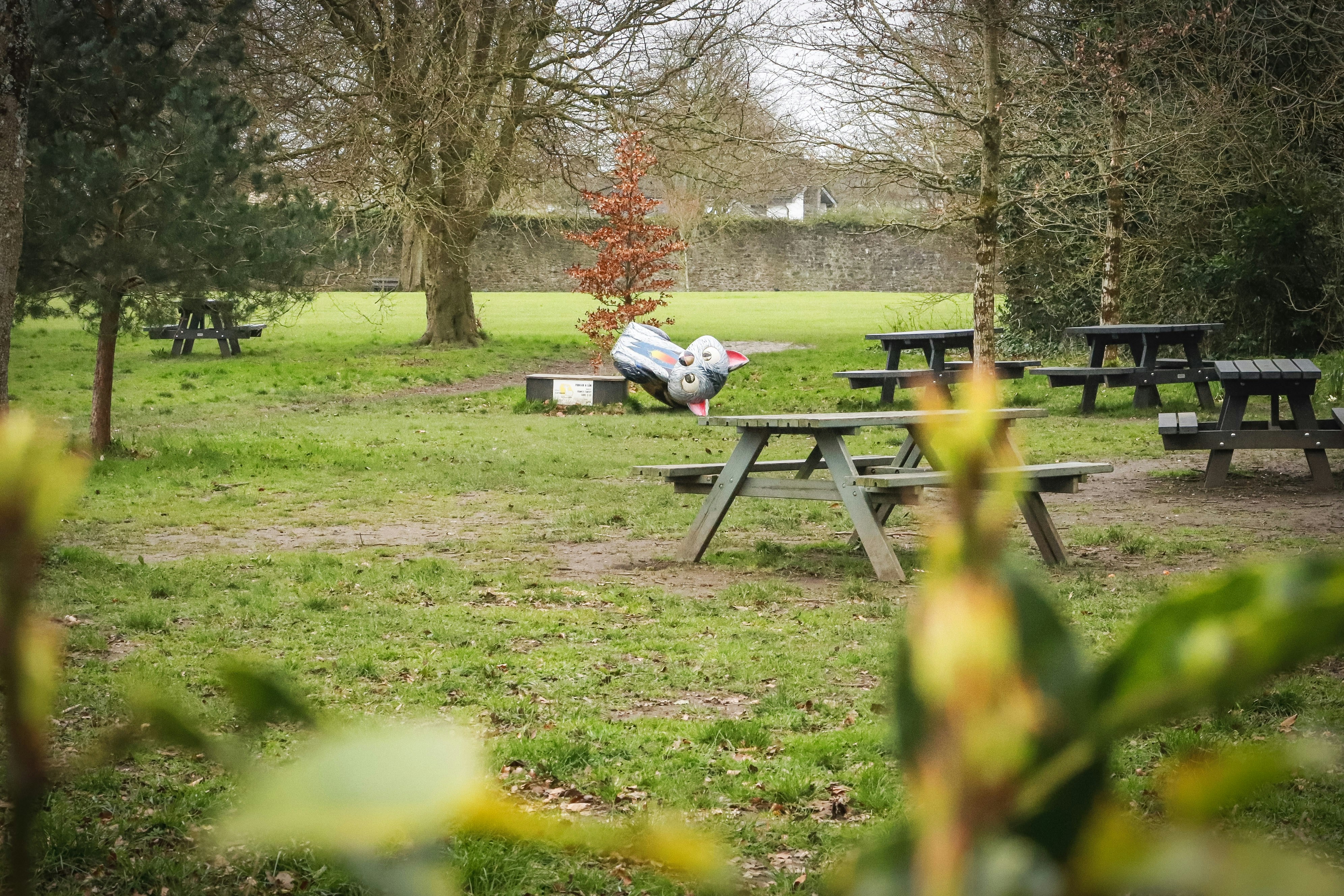 Person on a park bench under shady trees