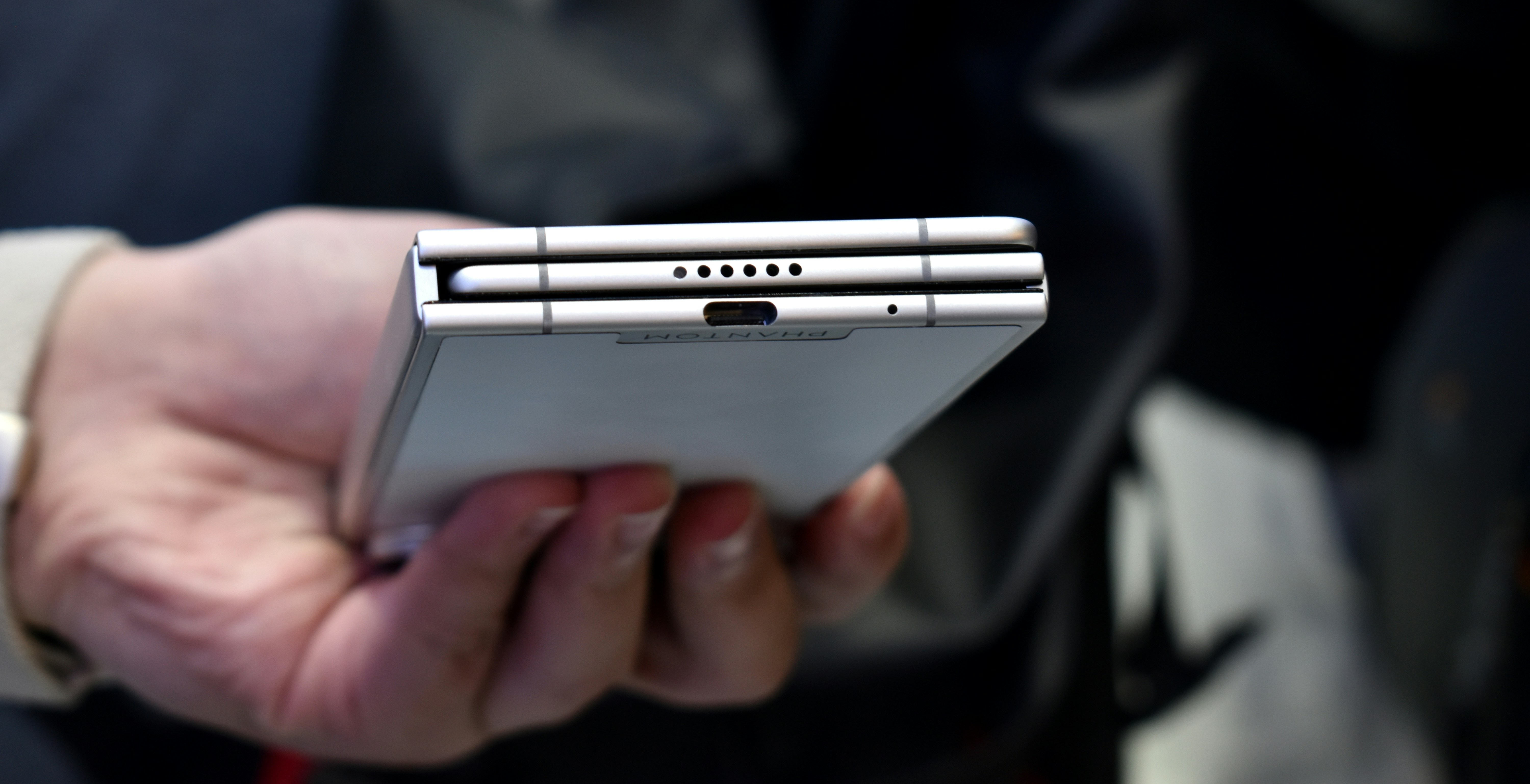 Person holding a silver foldable smartphone