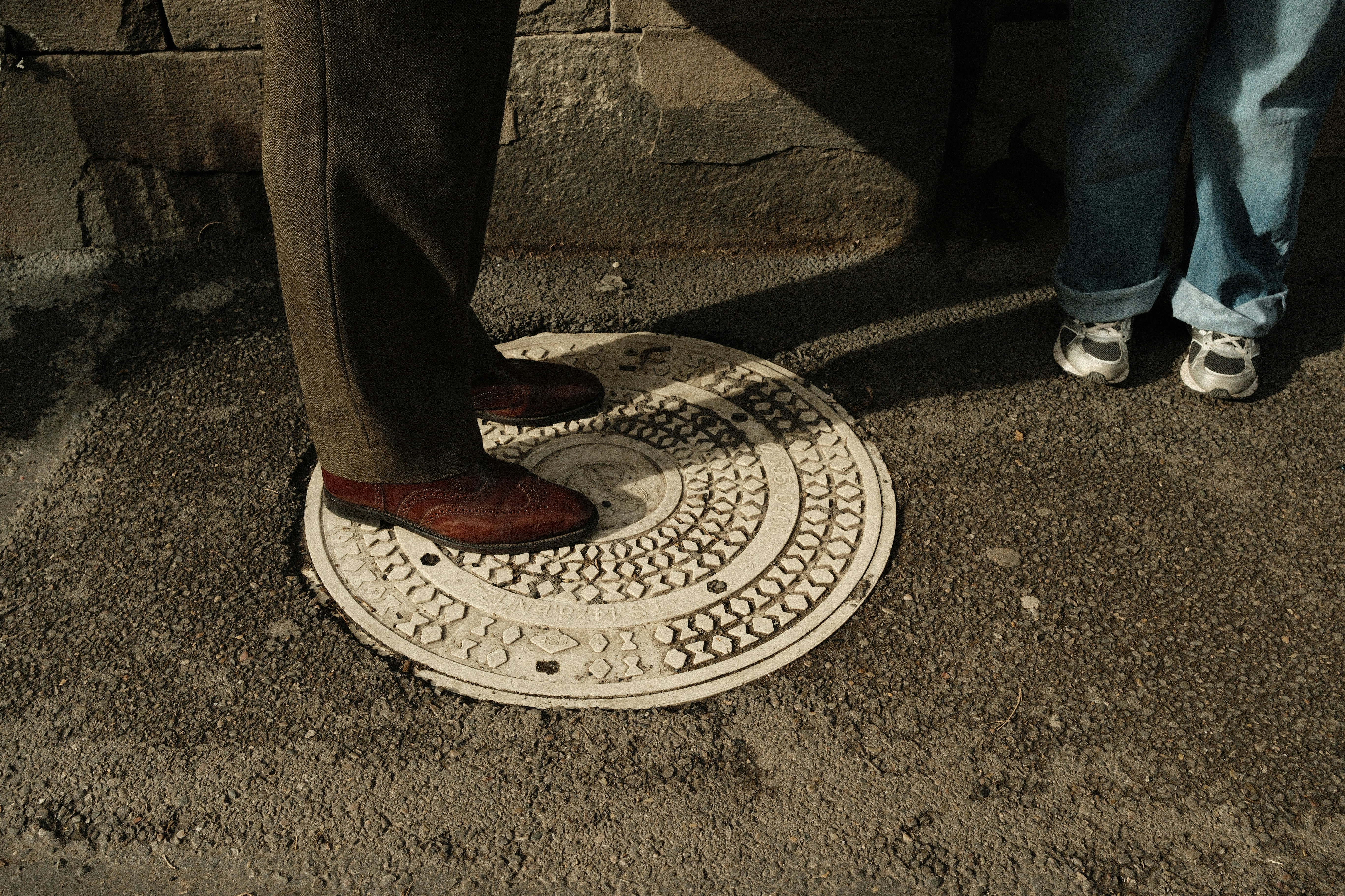 A person standing on a decorative manhole cover
