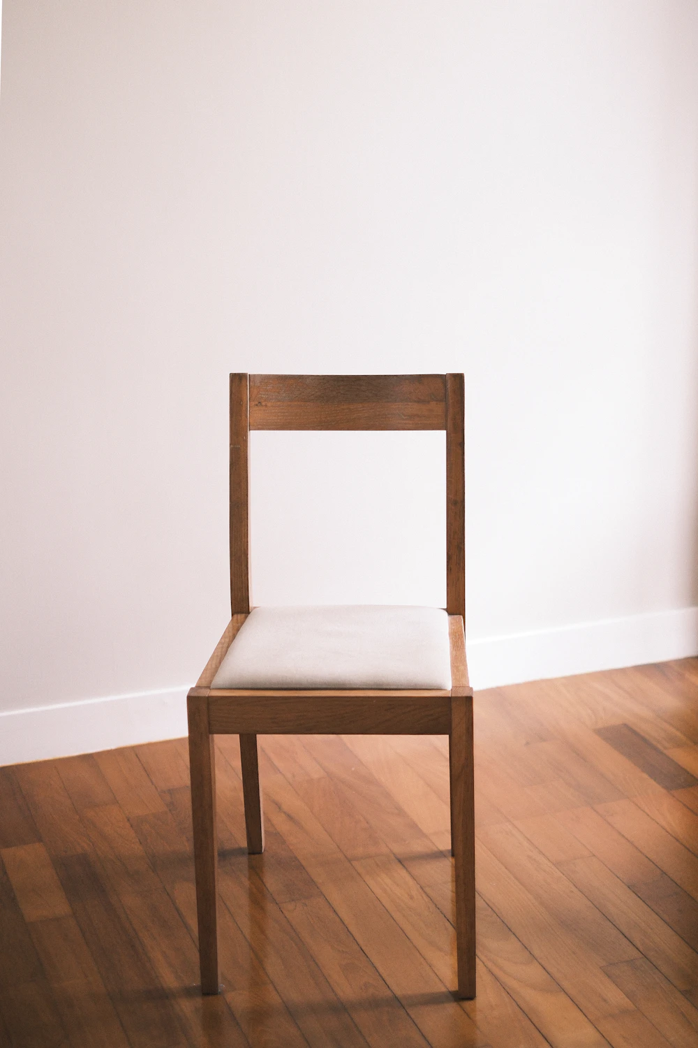 Simple wooden chair with a white cushion
