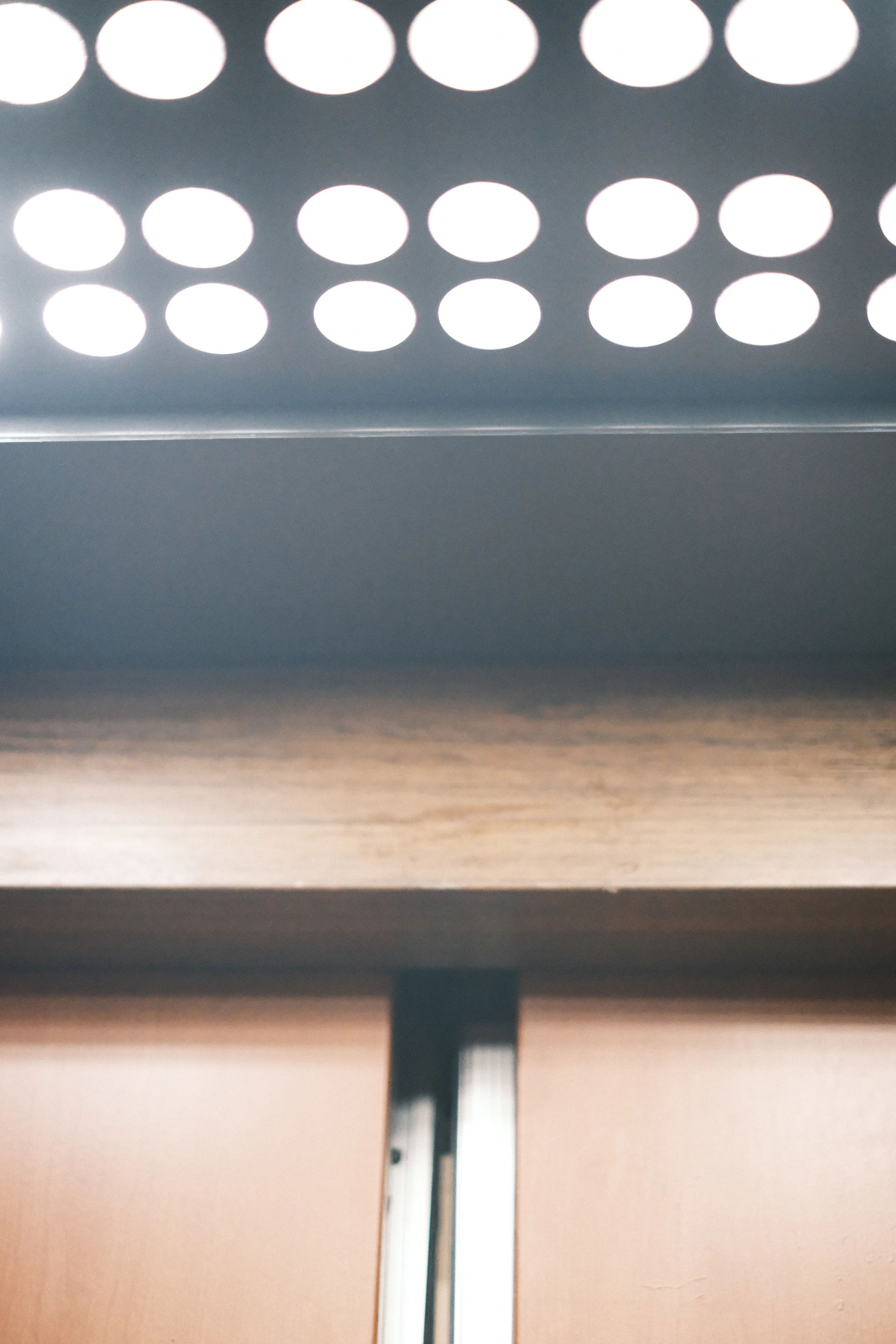 Rows of bright white lights above wooden panels