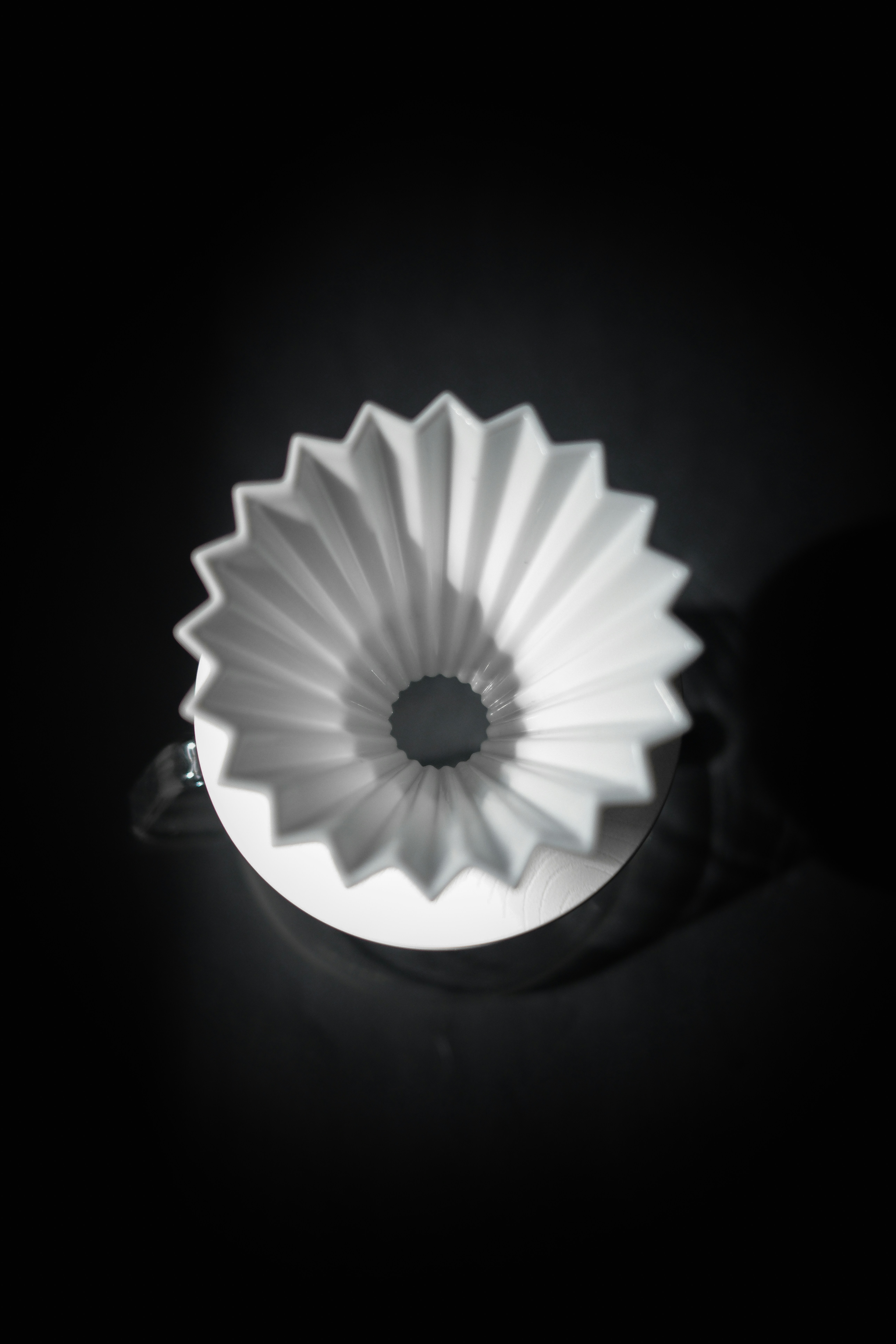 White origami coffee dripper on a dark background