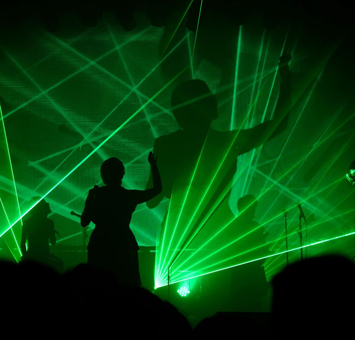 Nightlife stage with green laser beams and performers
