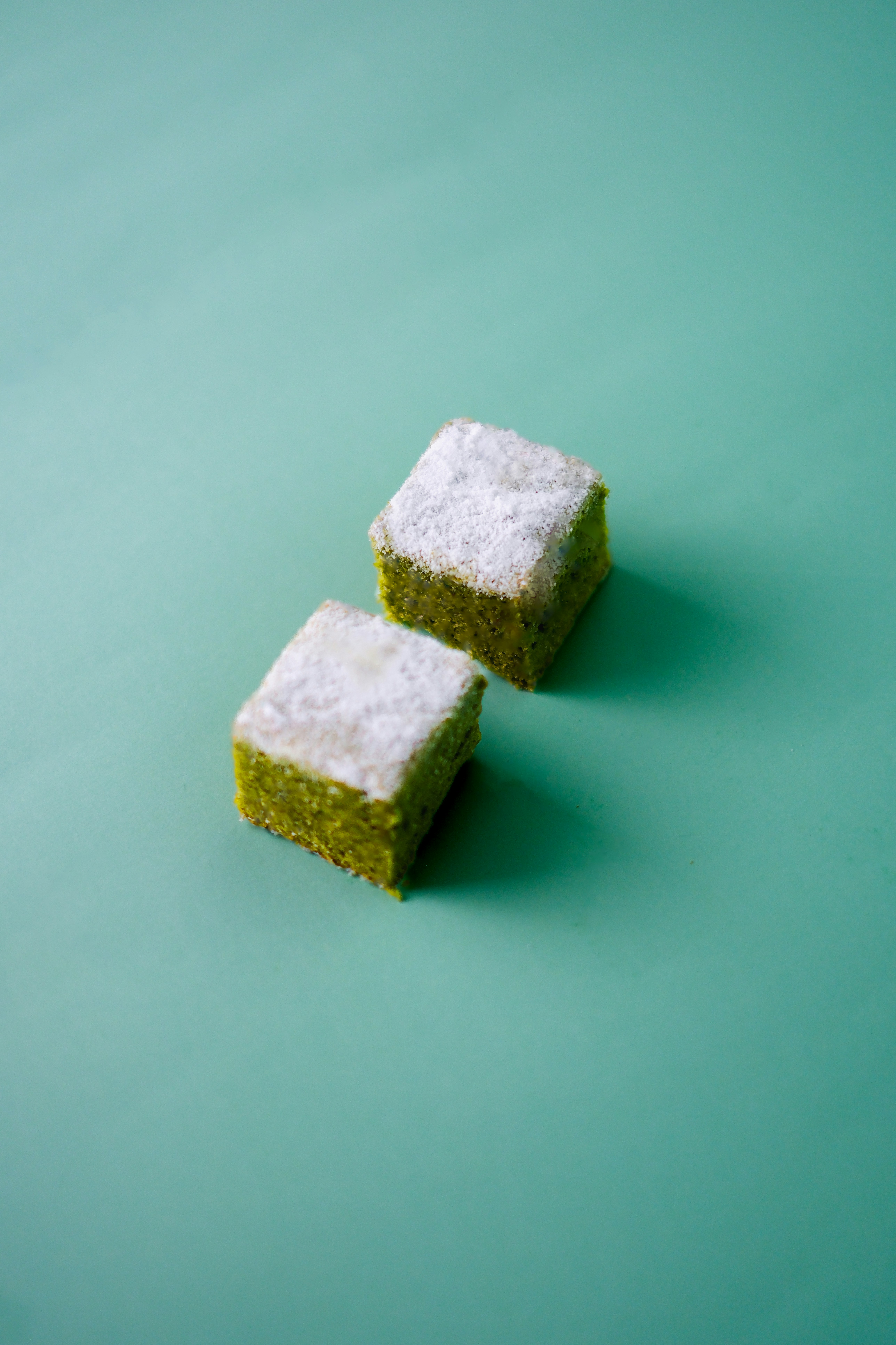 Two green cubes dusted with white powder