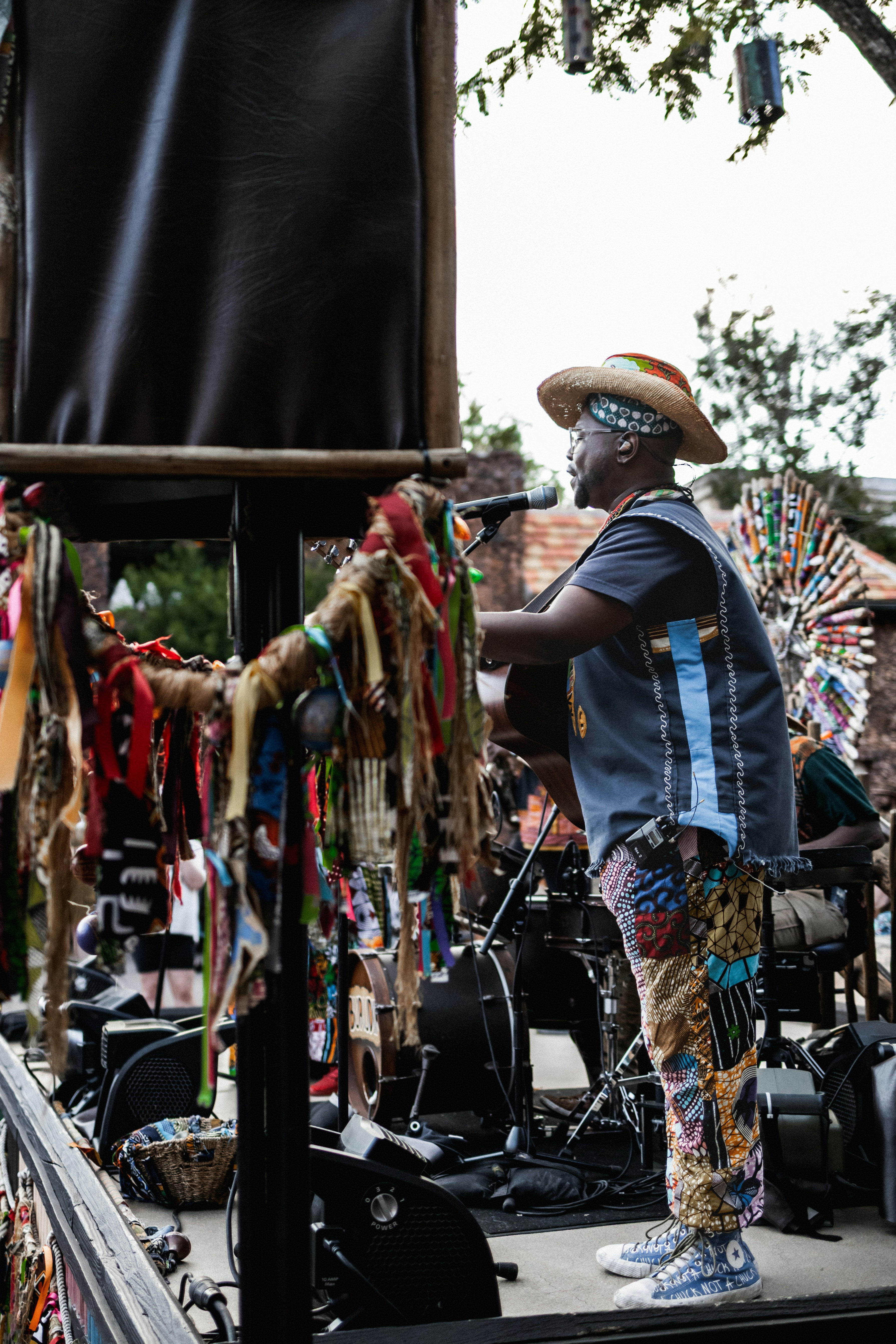 Man in colorful clothing plays guitar on stage