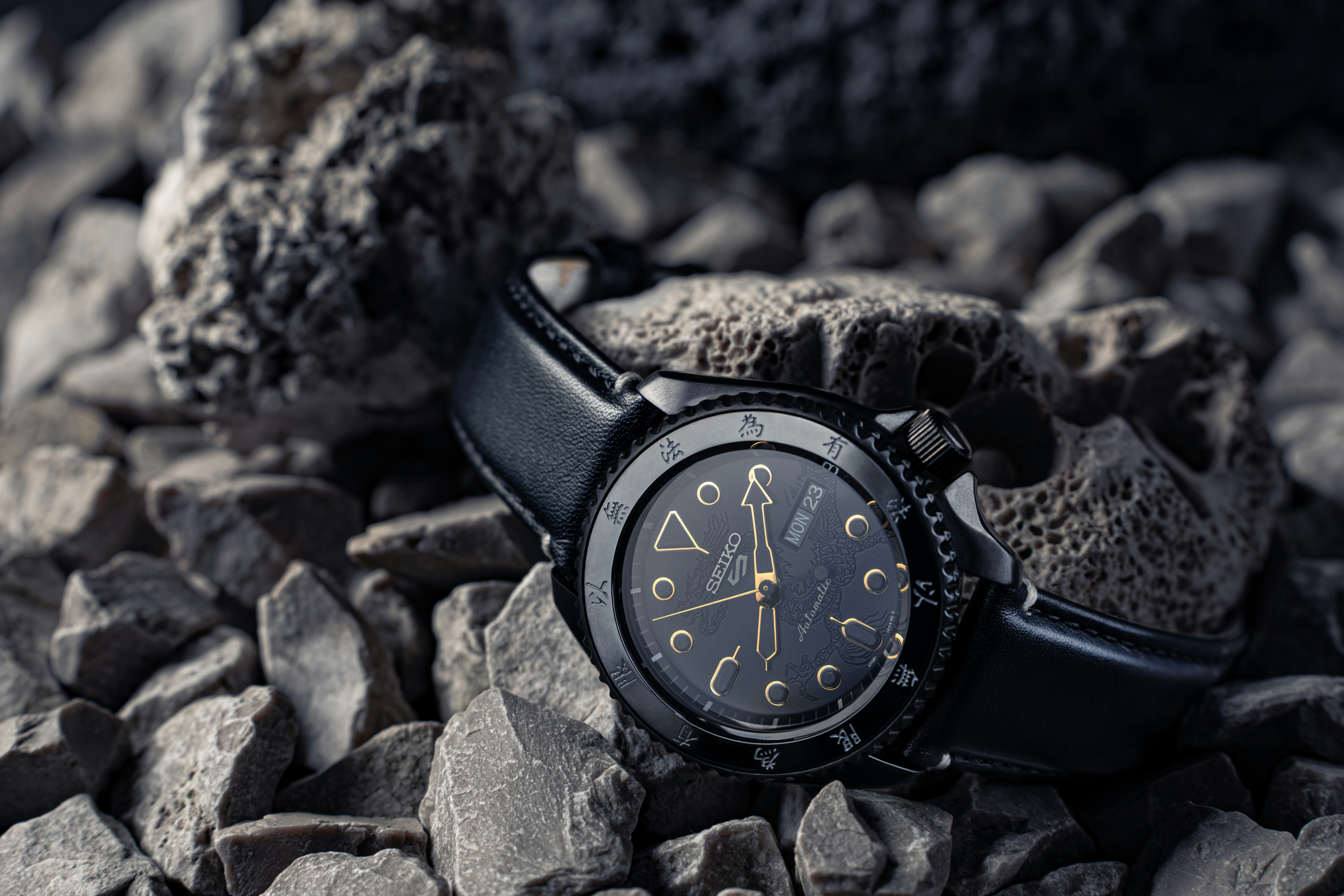 Orologio nero appoggiato su ghiaia e rocce