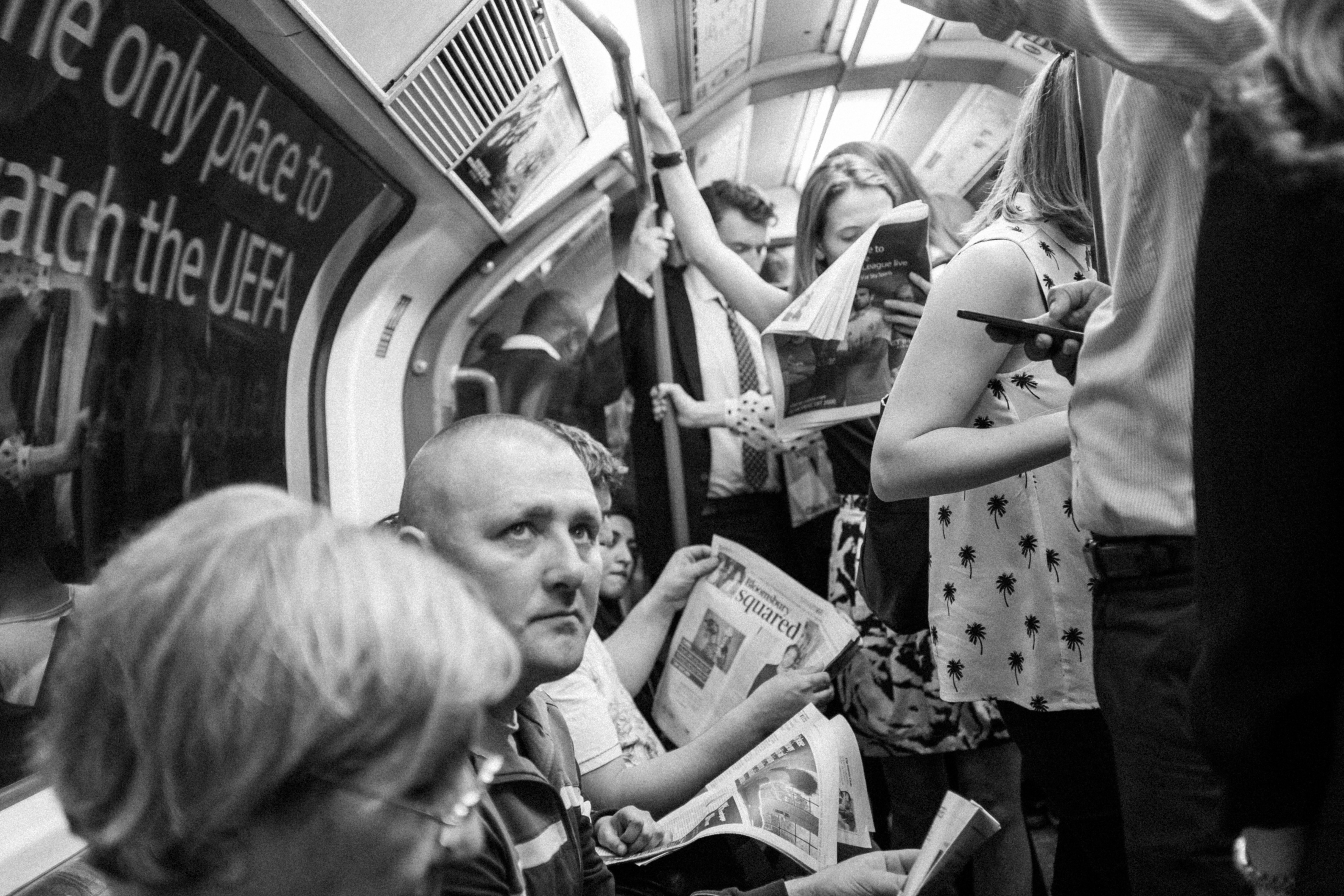 Orang-orang membaca di kereta bawah tanah yang ramai