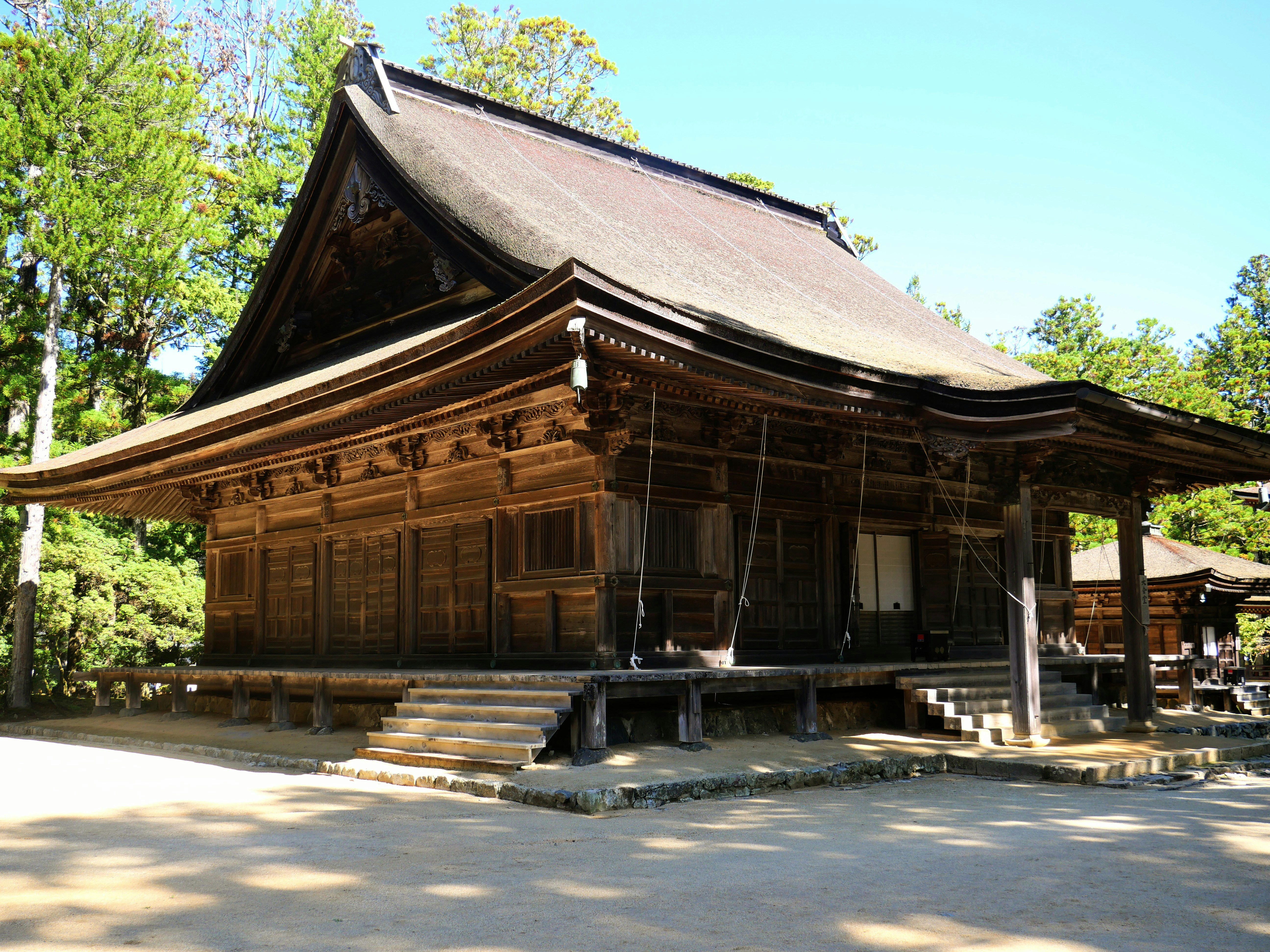 Traditional wooden japanese temple building with a large roof.