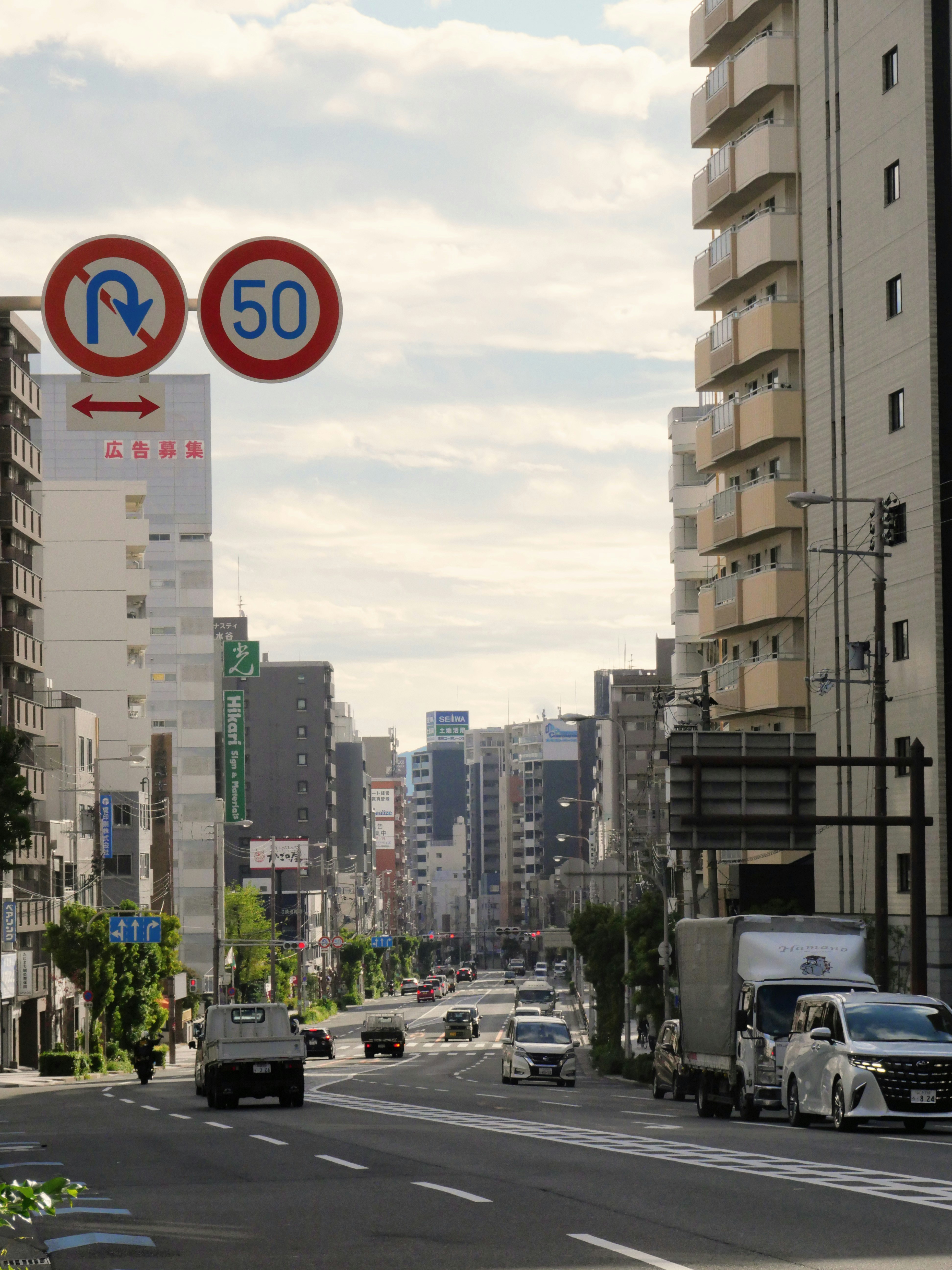 Street view of a city with tall buildings and traffic.