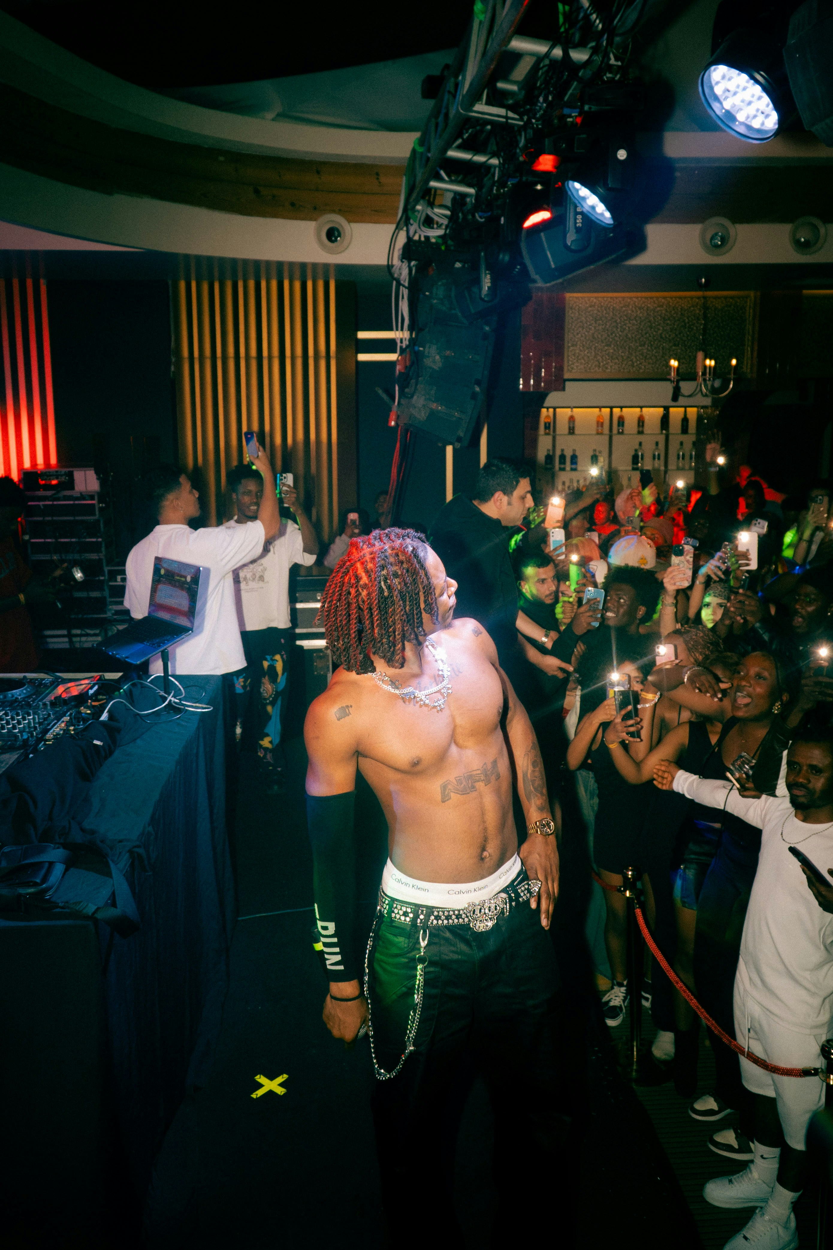 A shirtless man performs for a crowd at a concert