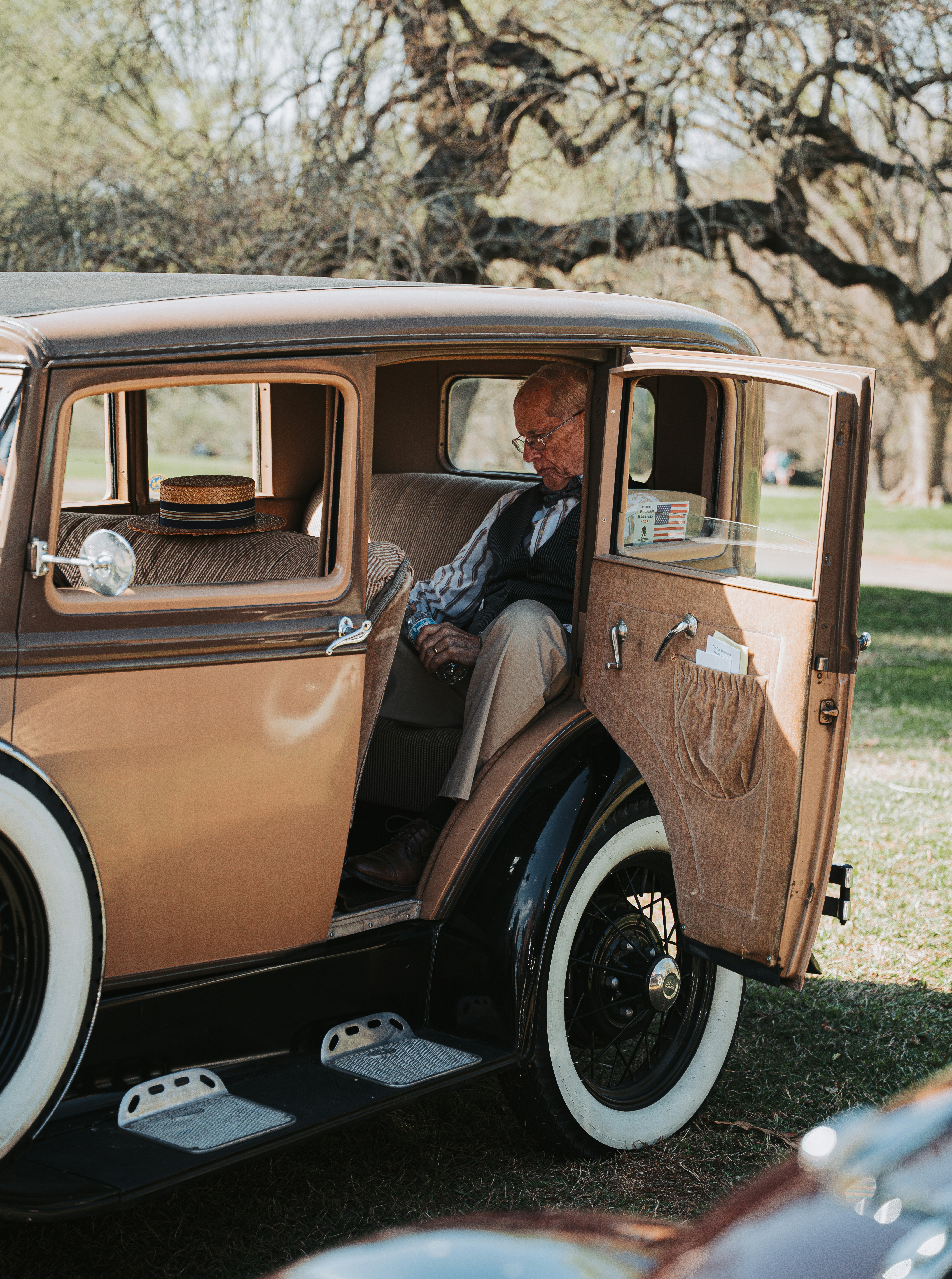 Homem idoso entrando em um carro antigo