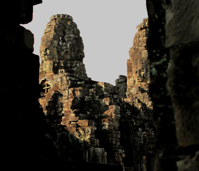 Bayon's carved face towers glowing in warm morning light (via Unsplash)