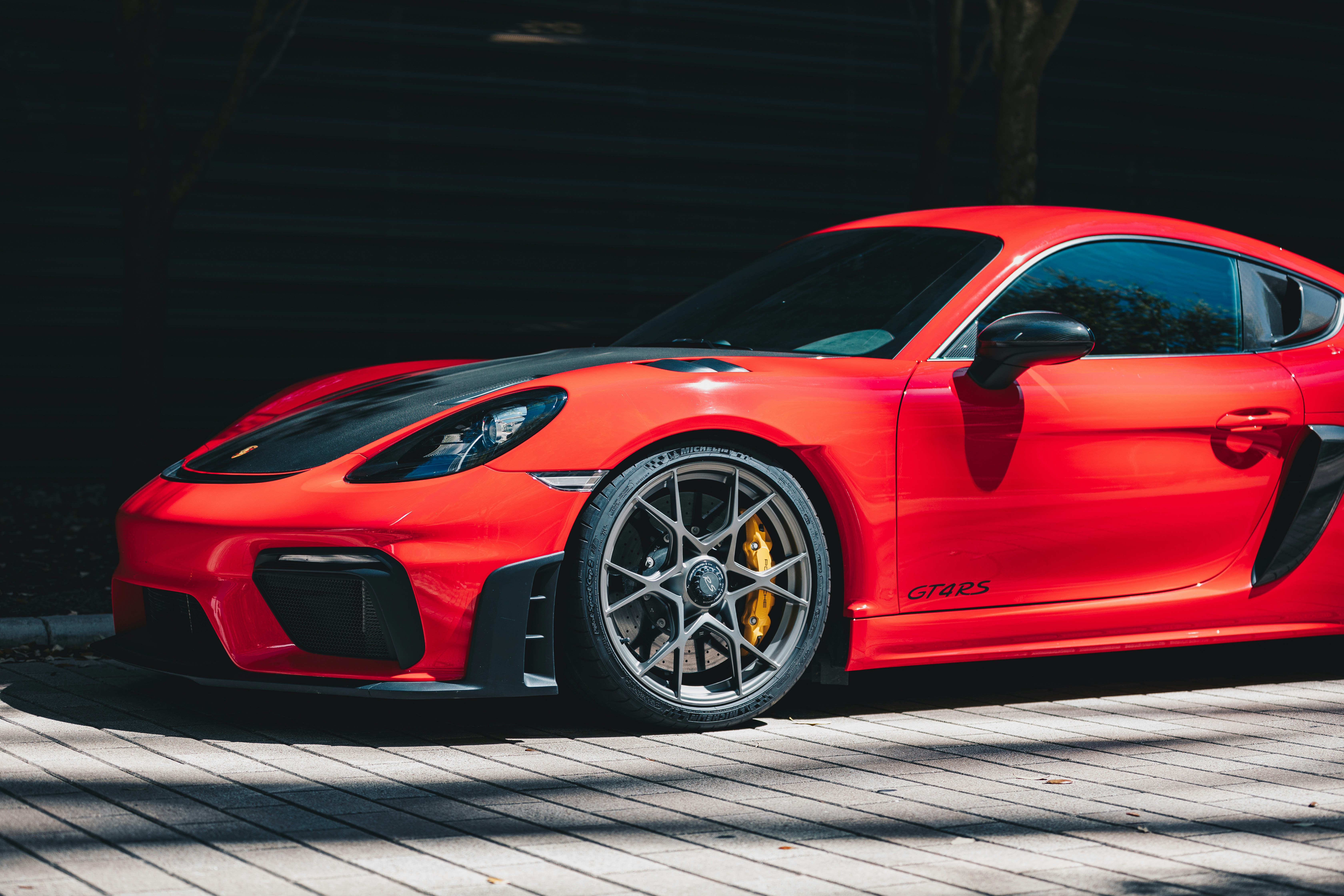 Ein roter Sportwagen, der draußen auf einer Holzterrasse geparkt ist
