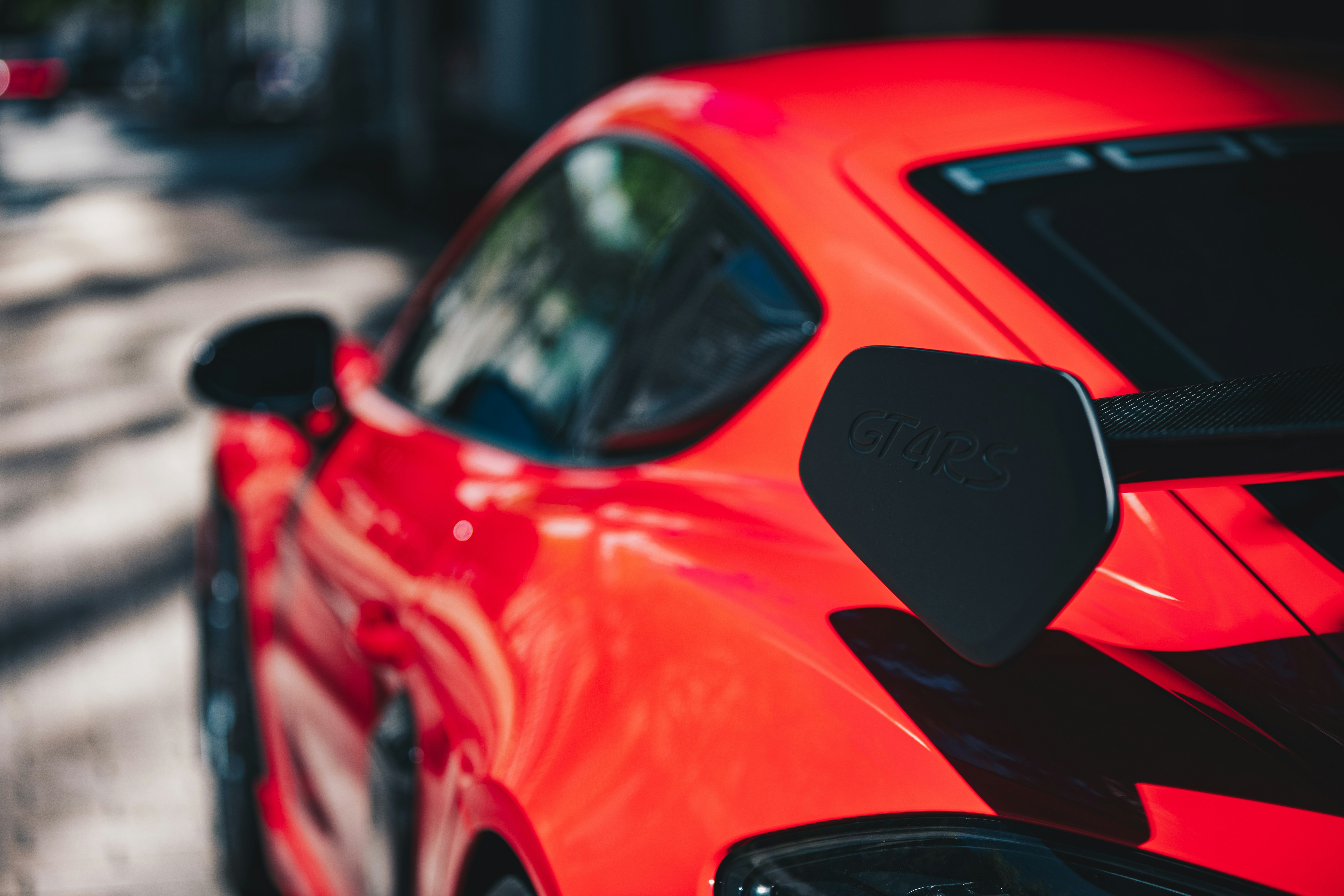 Nahaufnahme eines knallroten Sportwagens mit Spoiler.