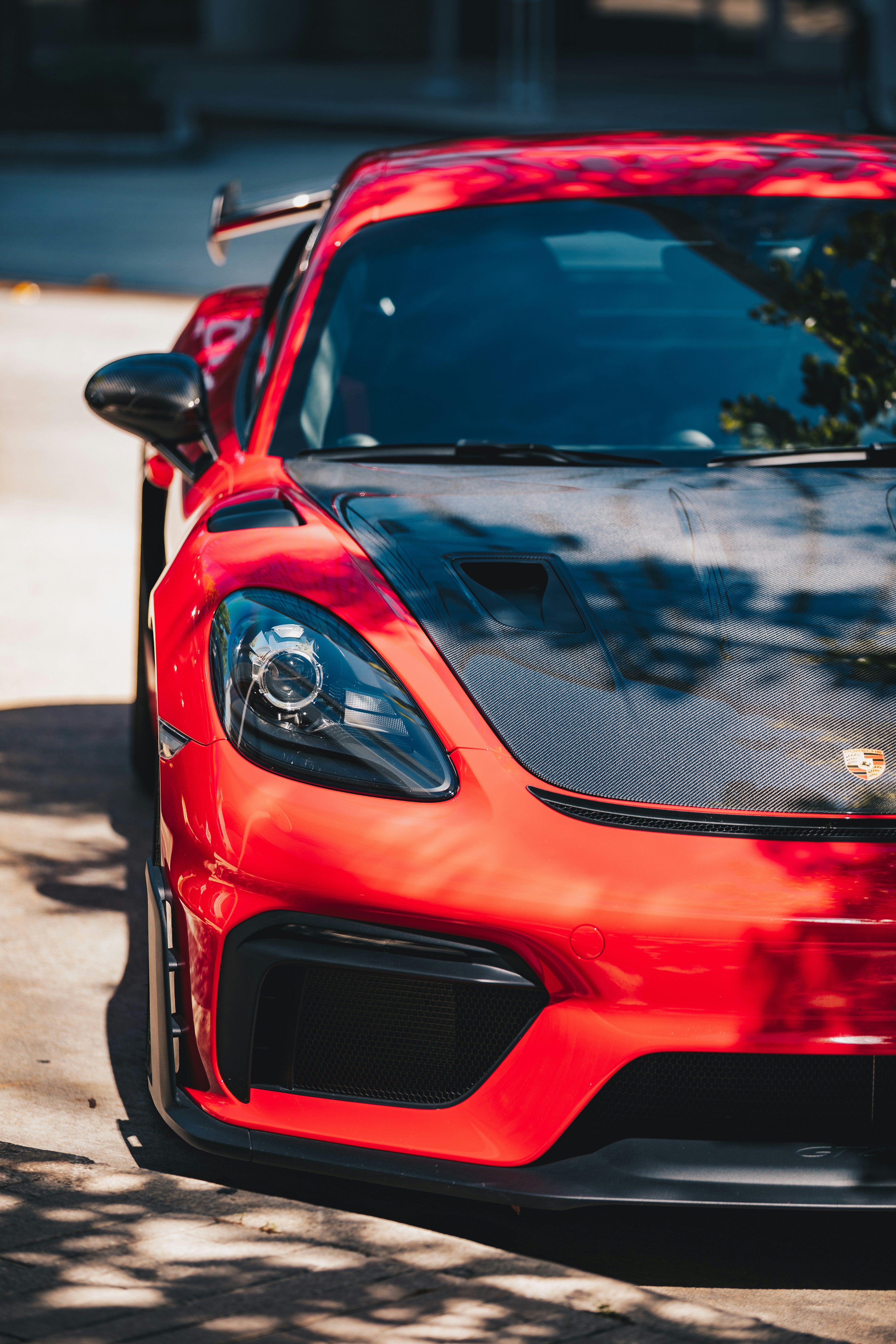 Roter Sportwagen mit schwarzer Motorhaube und Spoiler