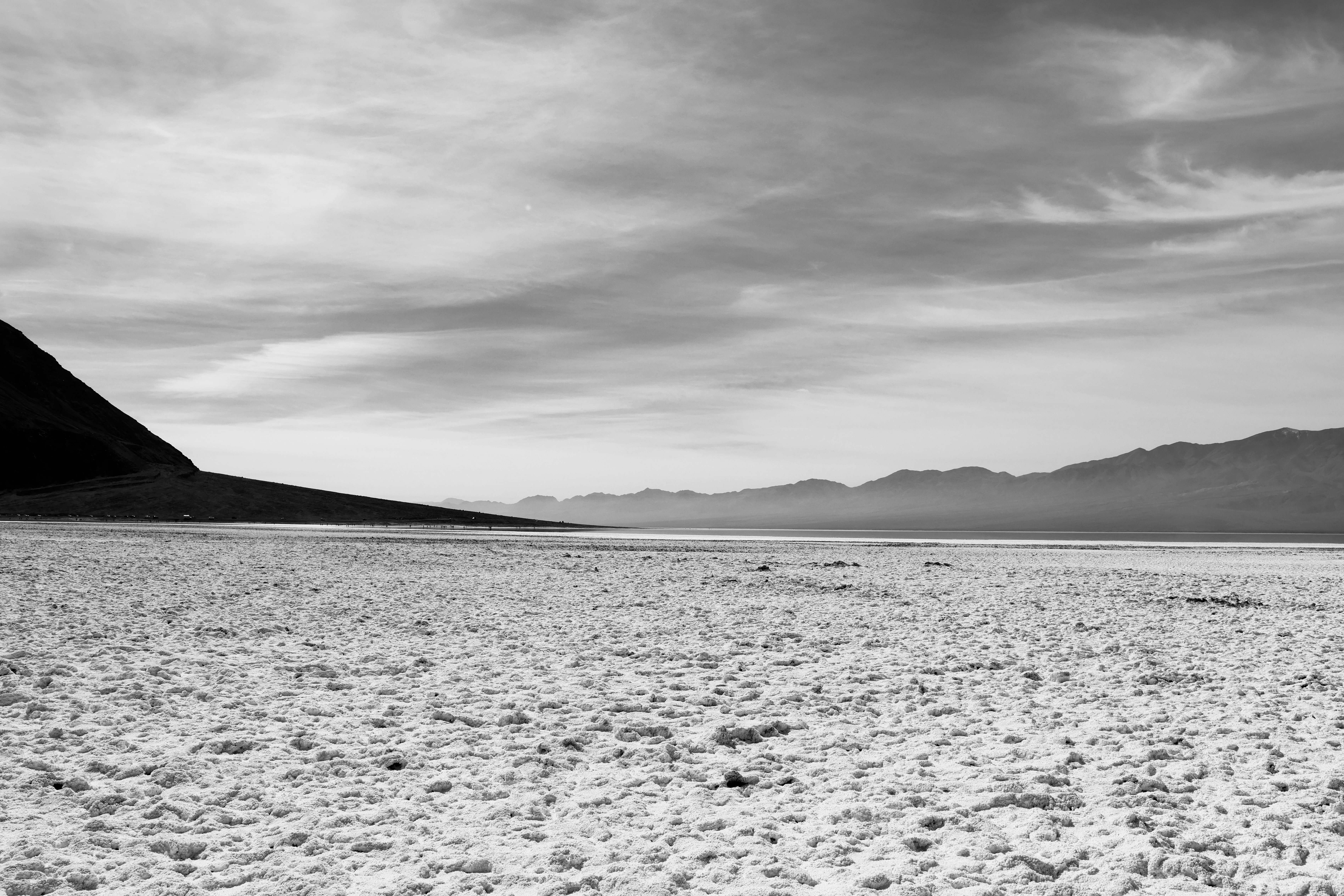 Vaste saline con montagne lontane sotto un cielo nuvoloso