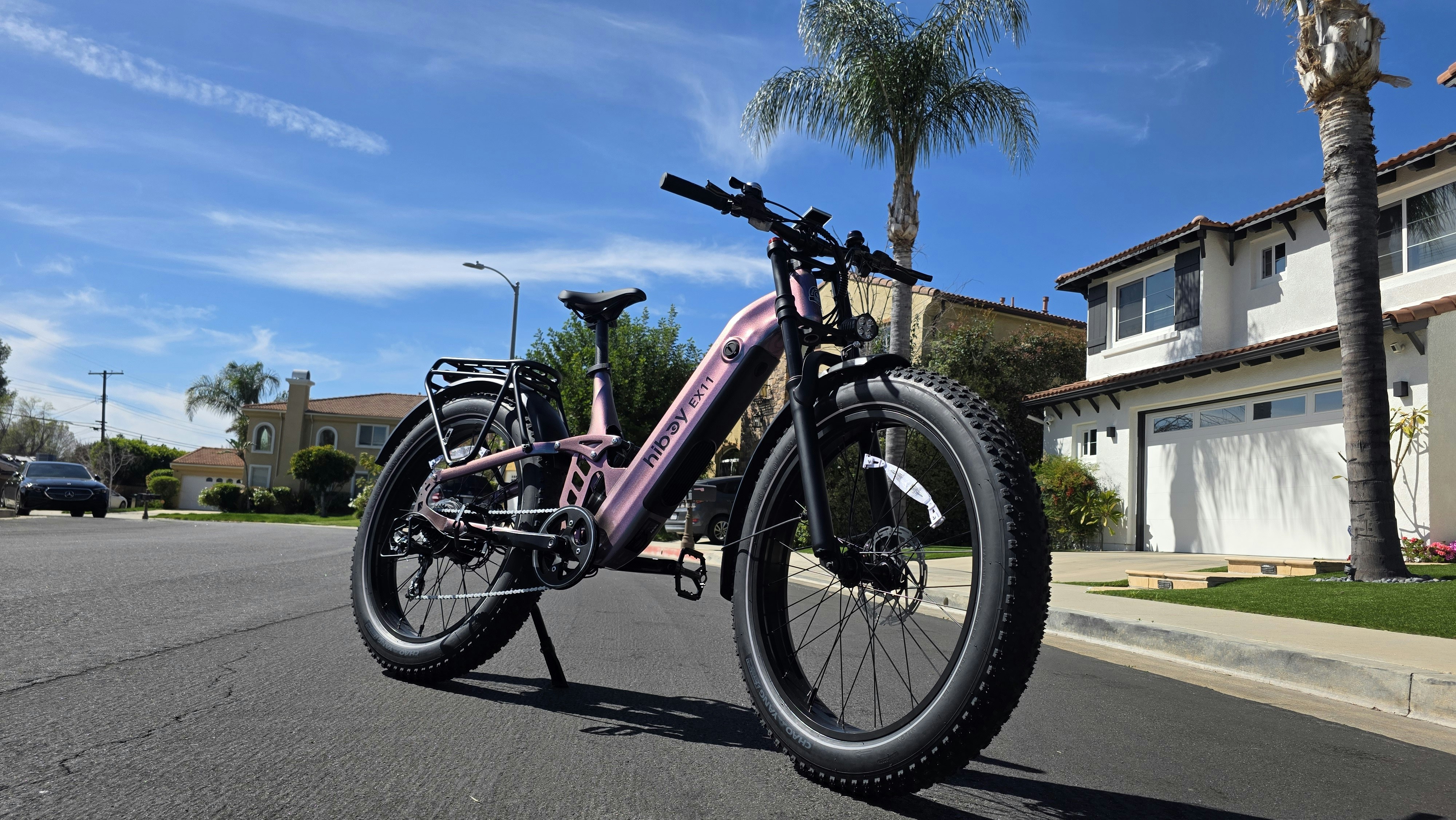 Pink electric cargo bike parked on suburban street