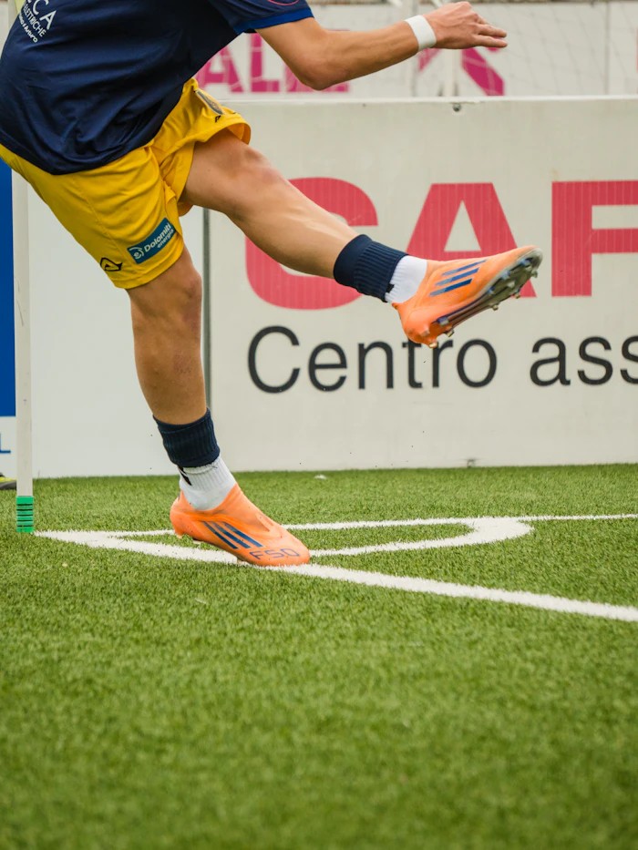Jogador uniformizado dominando a bola em campo