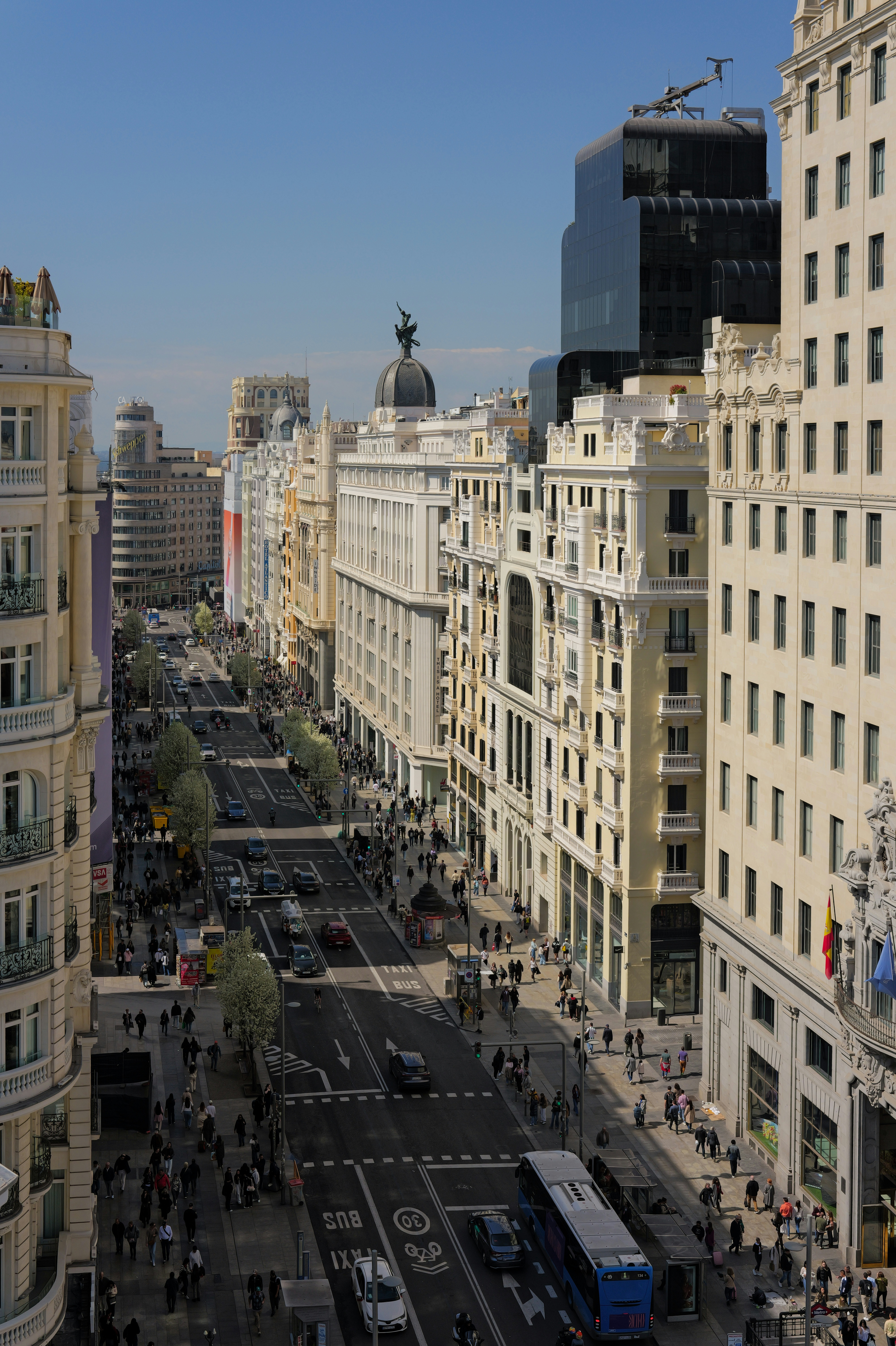 Busy city street with tall buildings and traffic.