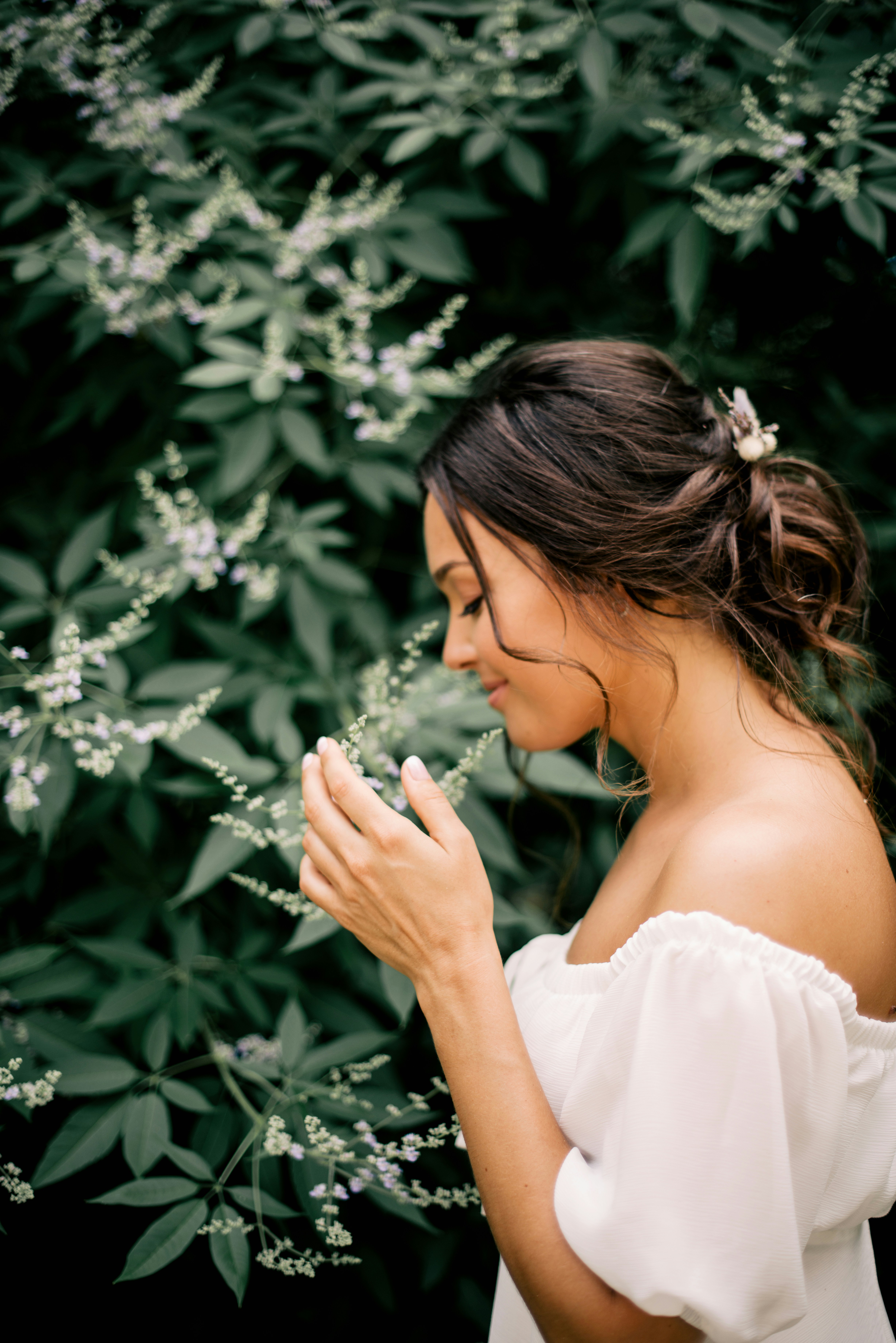 Young woman smelling white flowers in a garden